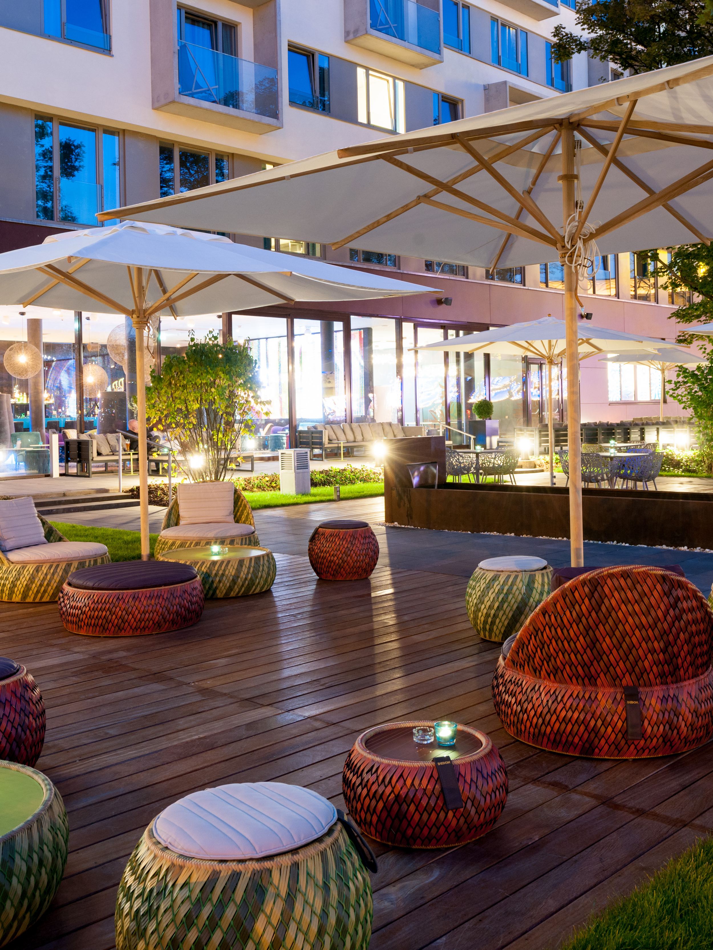 Hotel Wien Prater Motel One Außenbereich mit Sitzgelegenheiten und Sonnenschirm