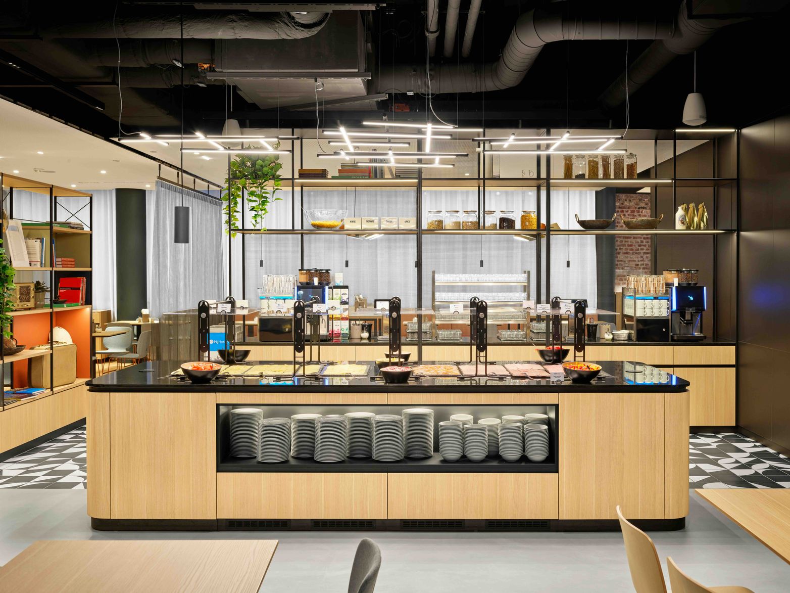 Moderne, helle Buffetstation mit Kaffeeautomaten, Tellern und Snacks in stilvollem Ambiente, ideal für einen entspannten Start in den Tag.