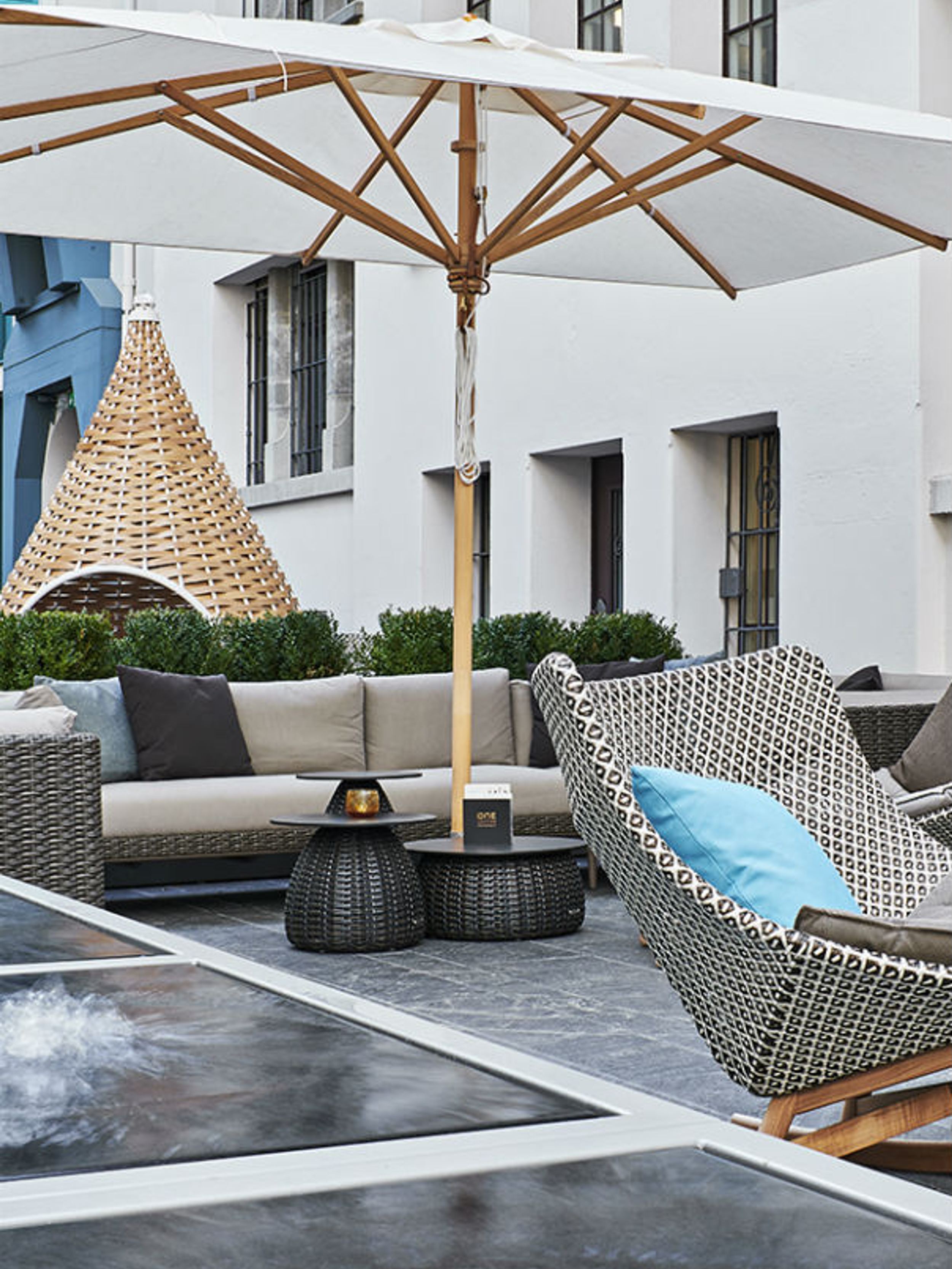 Hotel Zürich Motel One Outdoor Bereich mit Sesseln und Sonnenschirm