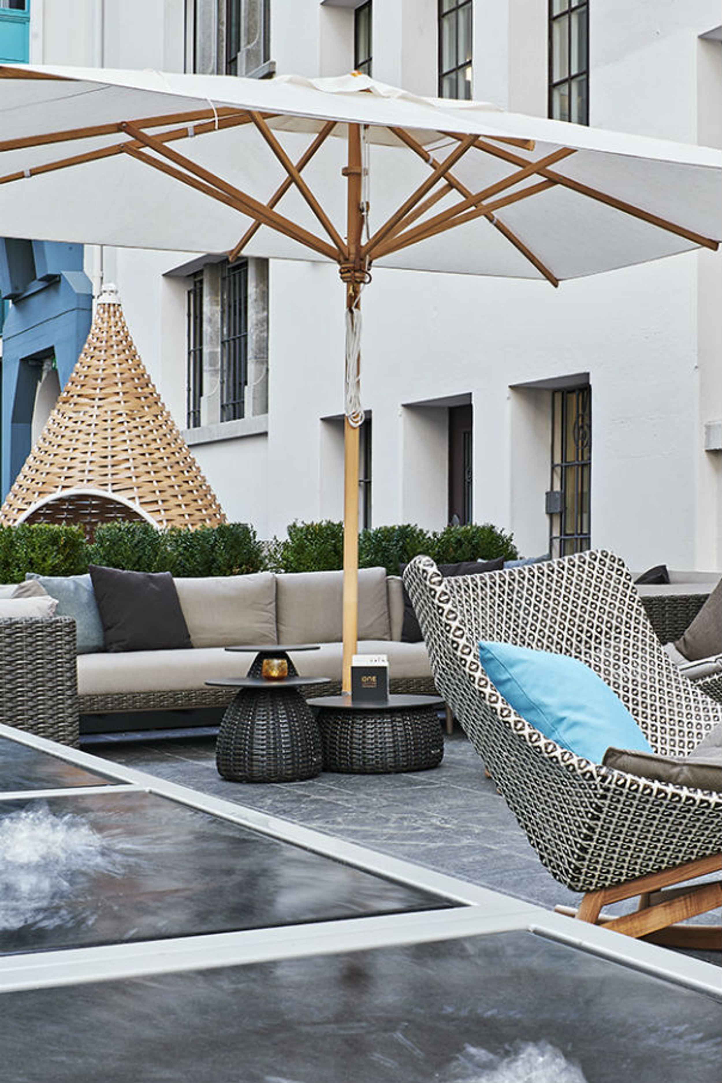 Hotel Zürich Motel One Outdoor Bereich mit Sesseln und Sonnenschirm