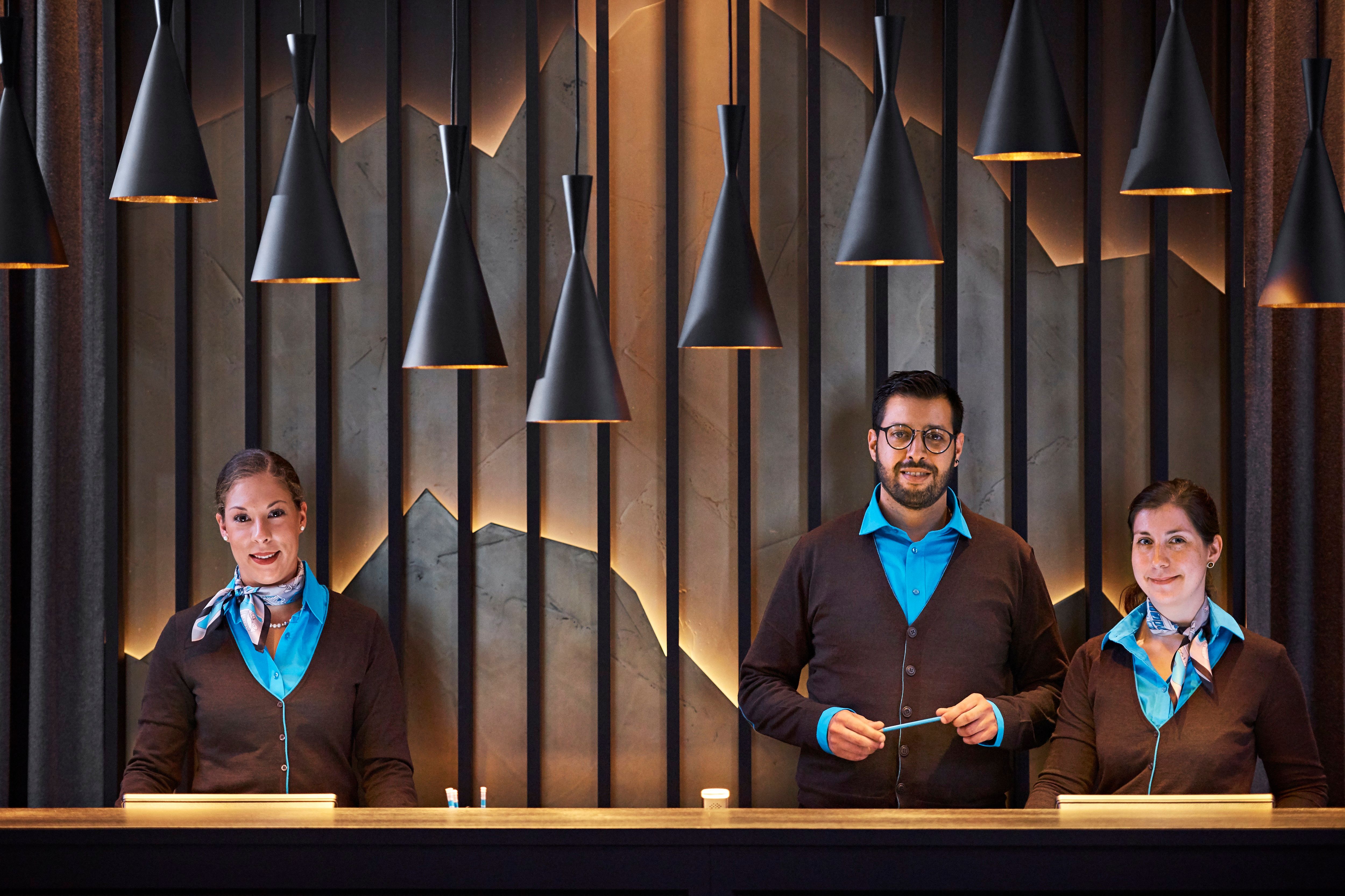 Hotel Zürich Motel One Rezeption mit drei Mitarbeitenden