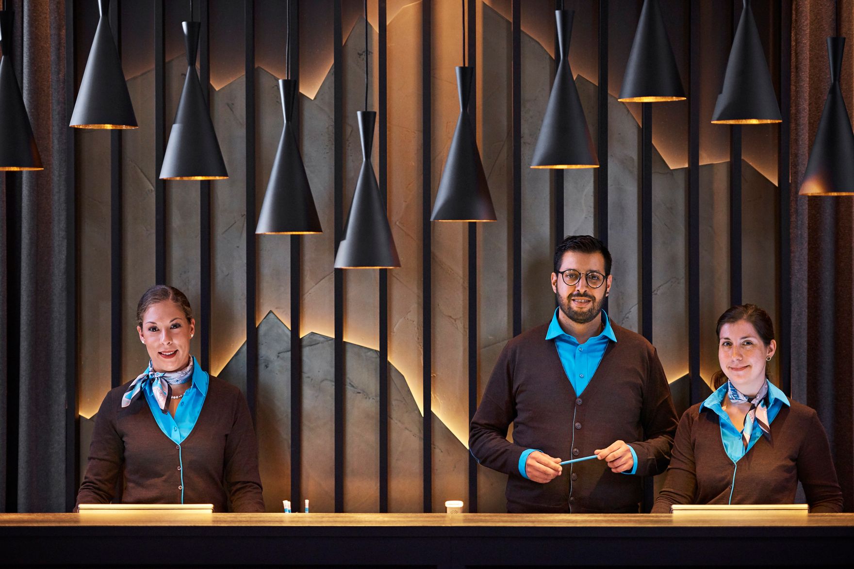 Hotel Zürich Motel One Rezeption mit drei Mitarbeitenden