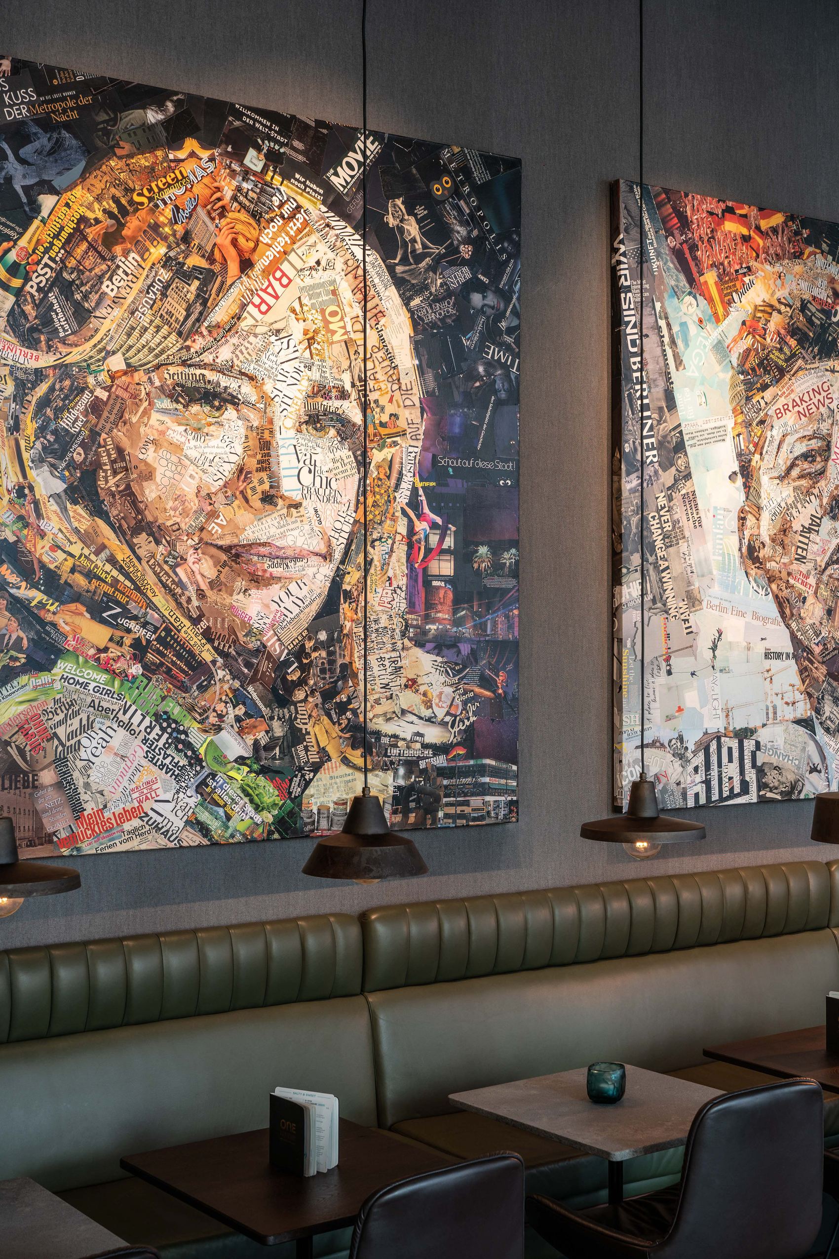 Zwei große, farbenfrohe Collage-Porträts an der Wand eines modernen Restaurants, die detailliert Gesichter aus Zeitungsausschnitten und Bildern darstellen, beleuchtet von stilvollen Hängeleuchten über Sitzgelegenheiten mit grünen Polstern.