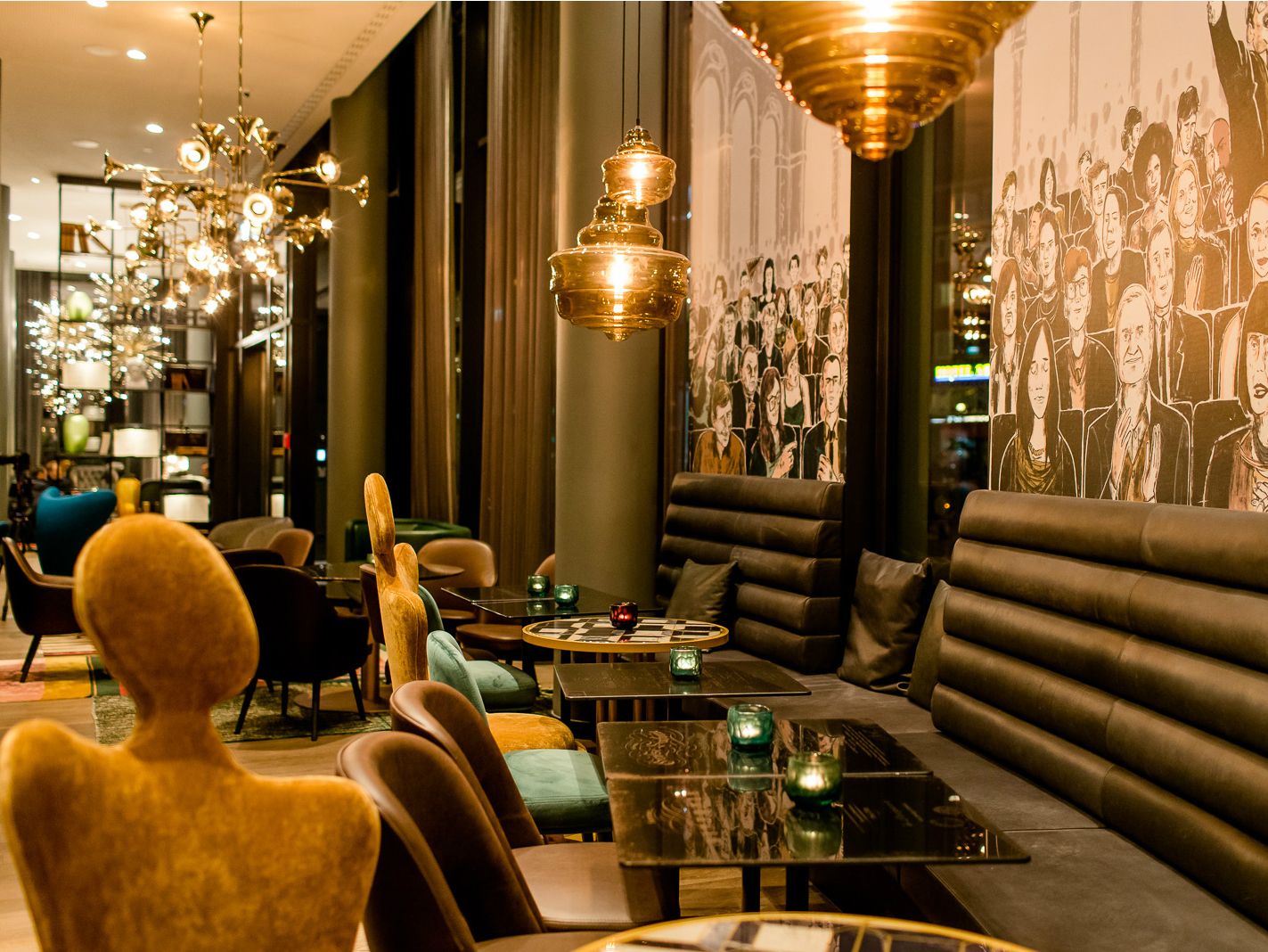 Moderne Hotelbar mit stilvoller Beleuchtung, bequemen Sitzbänken und Sesseln. Wände geschmückt mit großen Schwarz-Weiß-Porträts