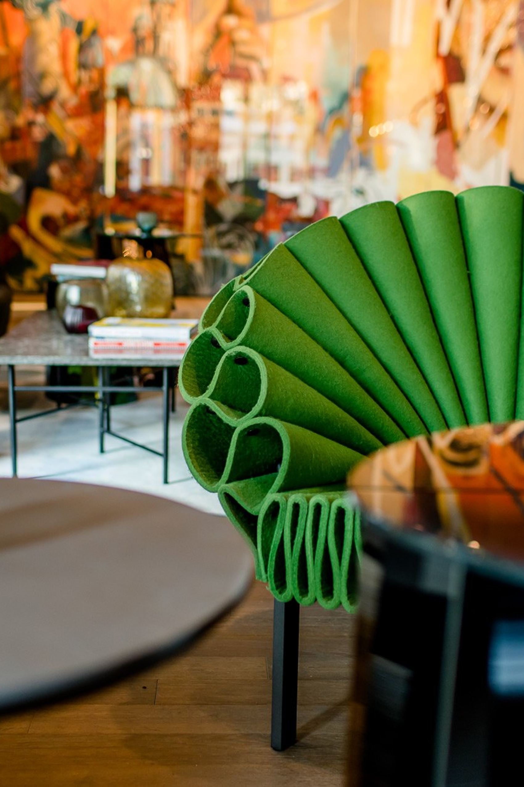 Gemütlicher Lounge-Bereich mit auffälligem, grünem, fächerförmigem Sessel, modernen Tischen und stimmungsvoller Kerzenbeleuchtung für entspannte Momente.