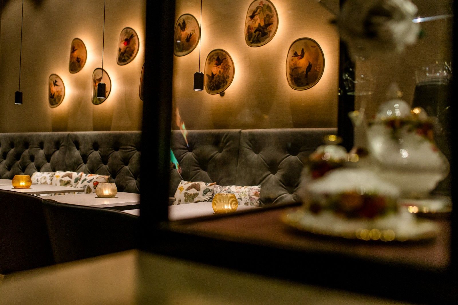 Gemütliche Lounge mit gepolsterten Sitzbänken, warmem Licht und dekorativen Wandbildern