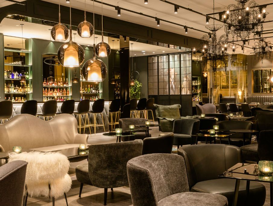 Stilvolle Hotelbar mit gemütlichen Sesseln, modernen Hängeleuchten und elegantem Ambiente,
