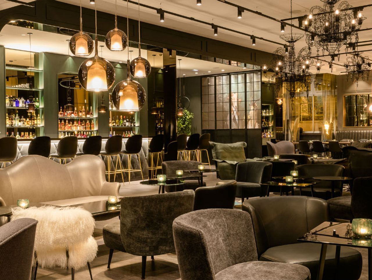 Stilvolle Hotelbar mit gemütlichen Sesseln, modernen Hängeleuchten und elegantem Ambiente,