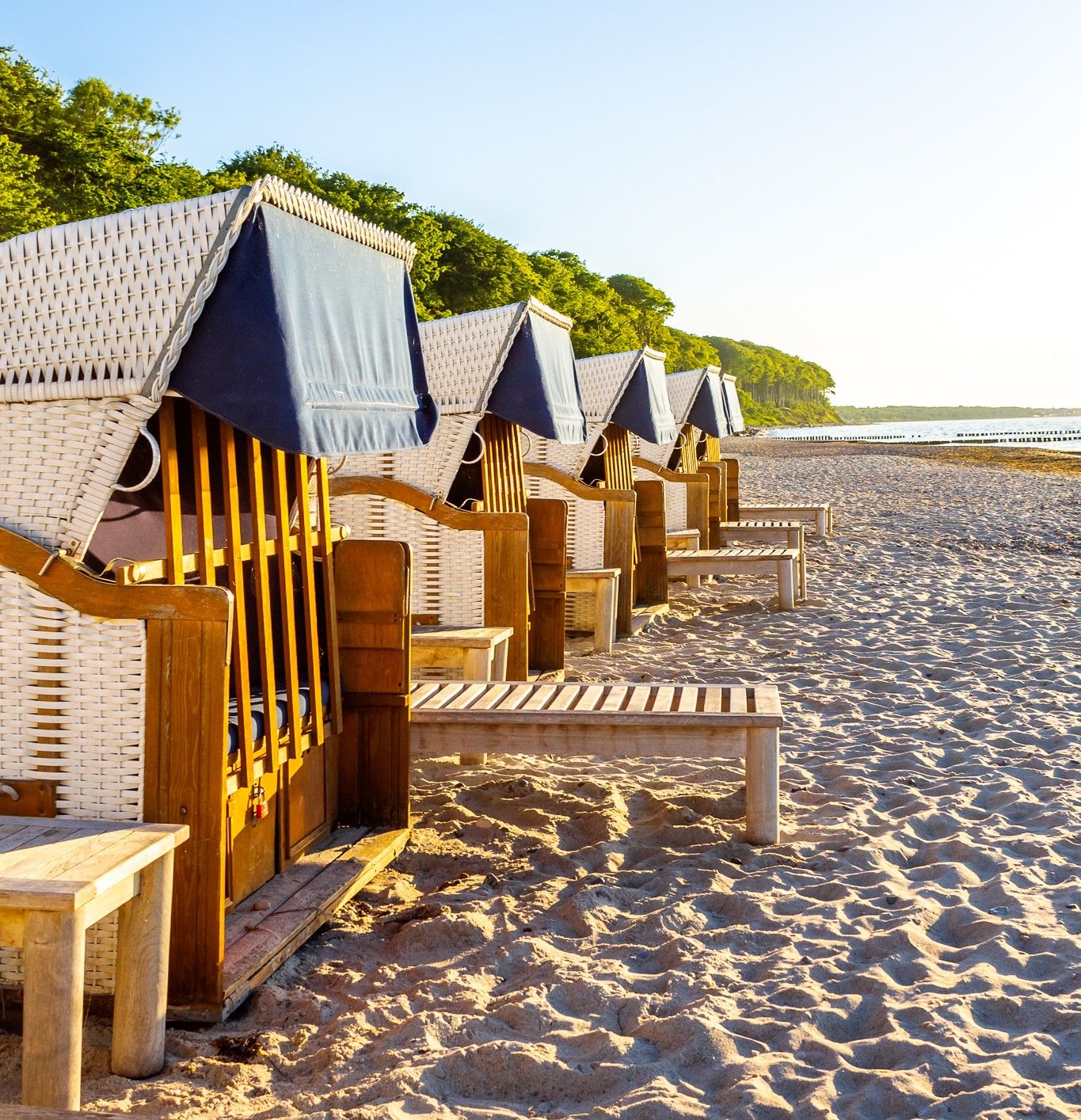 Strandkörbe stehen auf Sand an einem Strand in Luebeck