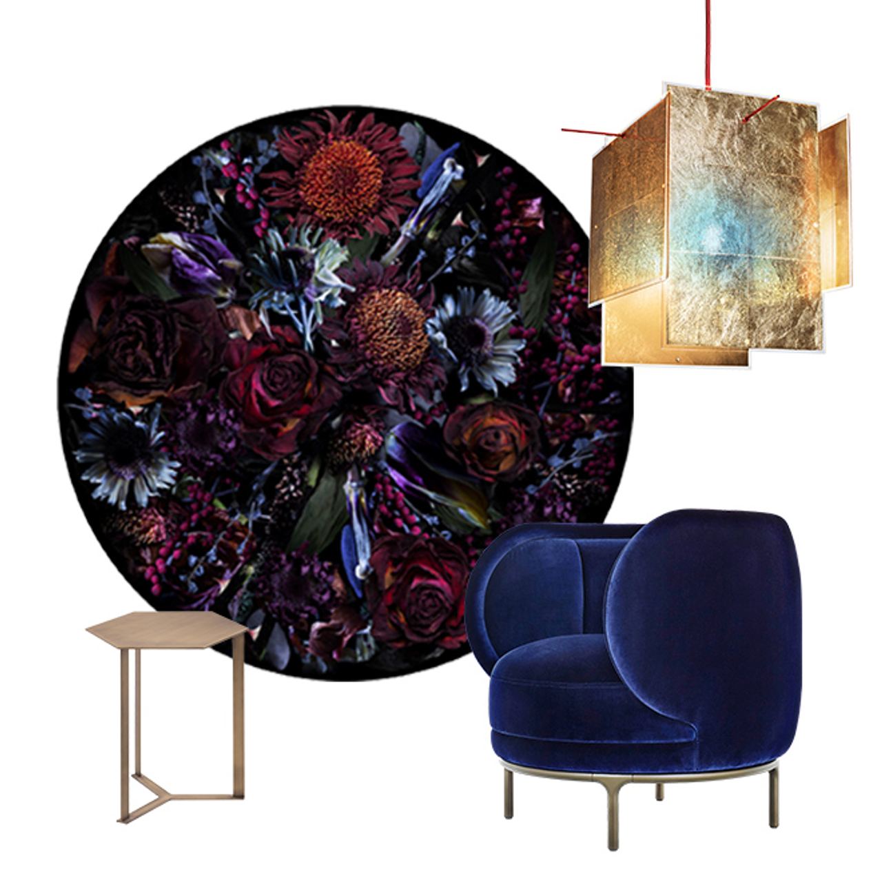 Dunkelblauer, eleganter Sessel neben kleinem Beistelltisch, darüber moderne goldfarbene Hängeleuchte, im Hintergrund rundes Wandbild mit dunklem, farbenfrohem Blumenmuster.