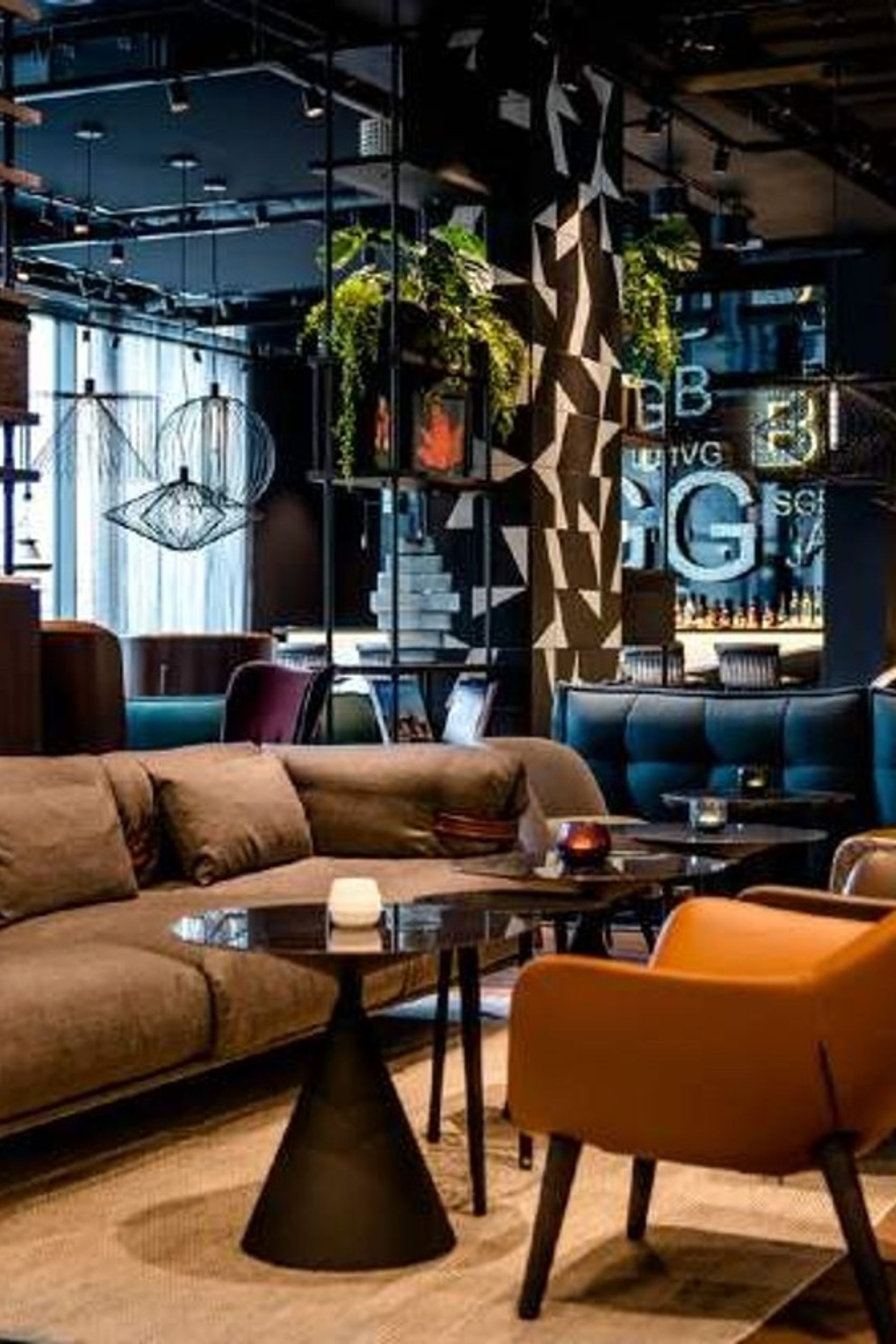 Motel One Hotel-Lounge mit bequemen Polstersofas und Sesseln, Beleuchtungselementen und stilvoller Dekoration