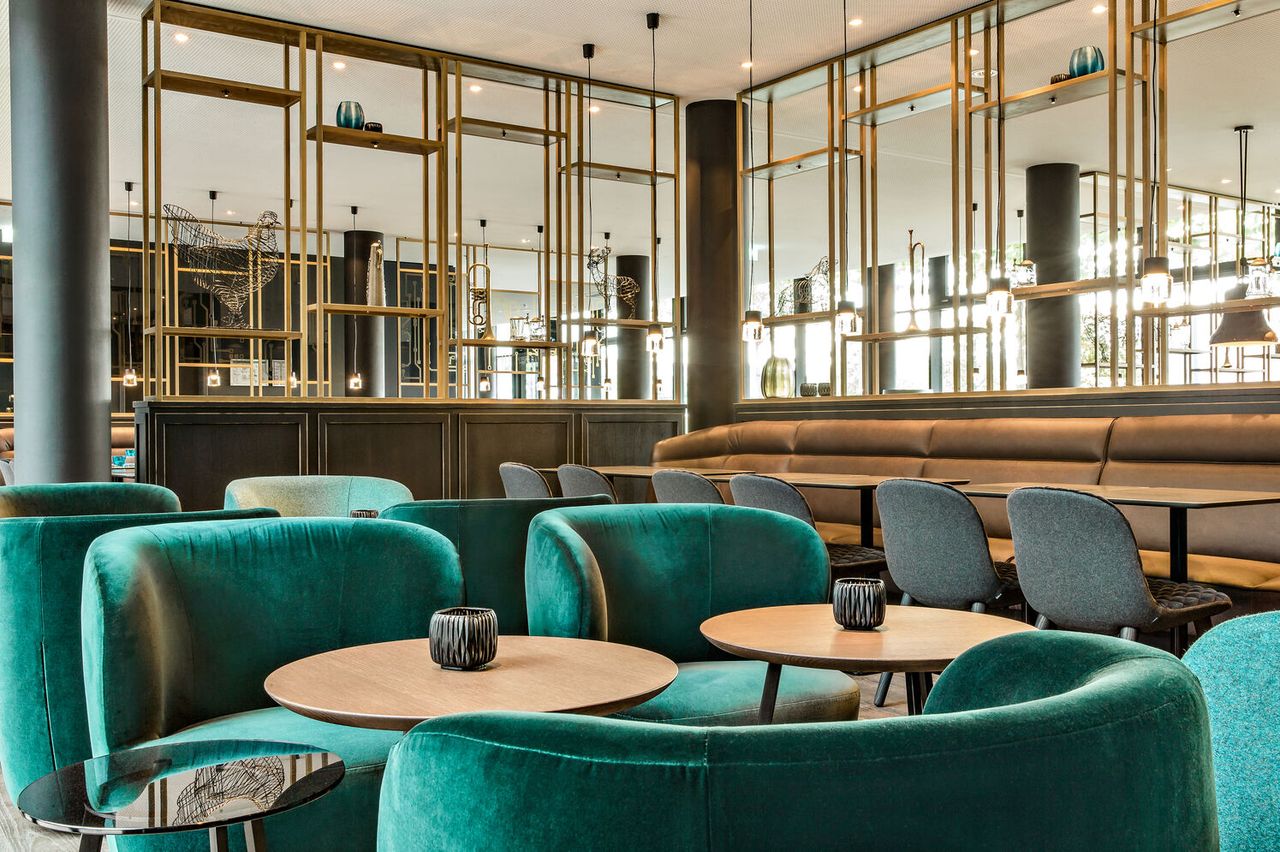 Hotel München Parkstadt Schwabing Motel One helle Lounge mit Sesseln, Stühlen und Sitzbank