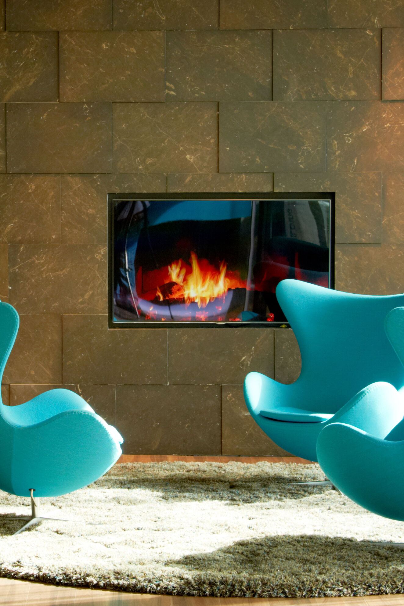 hotel Amsterdam Motel One three egg chairs in front of a TV with a fireplace image hotel Amsterdam Motel One three egg chairs in front of a TV with a fireplace image