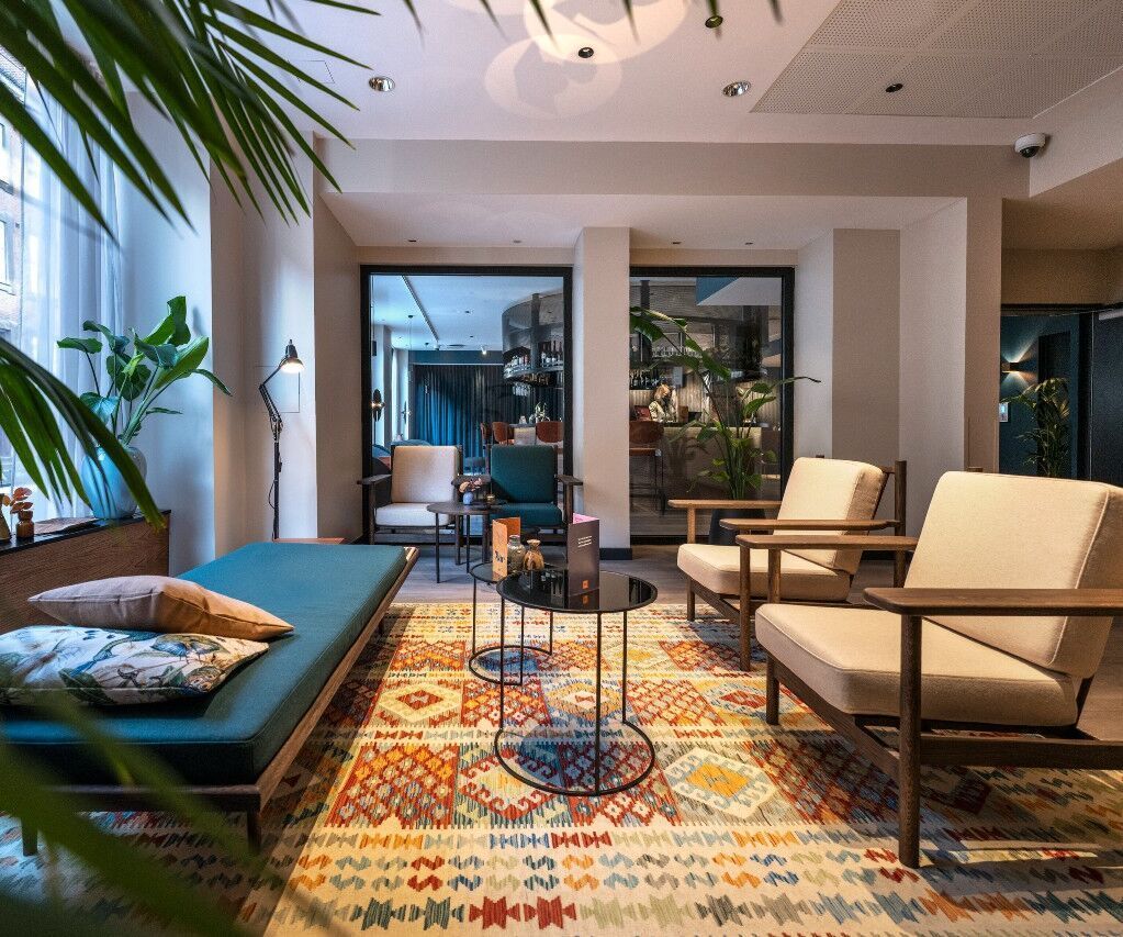 Hotel Kopenhagen Motel One lichtdurchflutete Lounge mit gemütlicher Sitzgruppe, bestehend aus Sesseln und Sitzbank