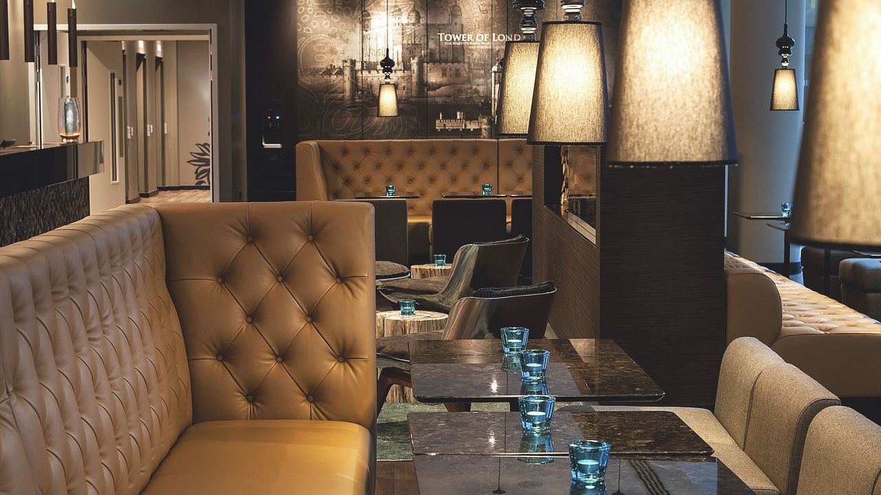 hotel London Tower Hill Motel One lounge with couch and several armchairs and tables
