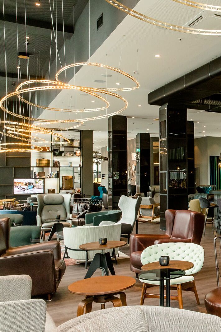 Hotel Berlin Hauptbahnhof Motel One große und lichtdurchflutete Lounge mit mehreren Sitzgelegenheiten sowie Bar mit Barhockern