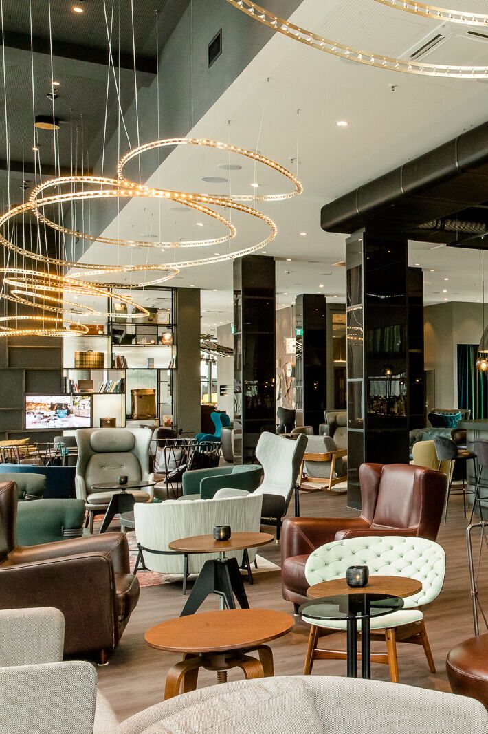 Hotel Berlin Hauptbahnhof Motel One große und lichtdurchflutete Lounge mit mehreren Sitzgelegenheiten sowie Bar mit Barhockern