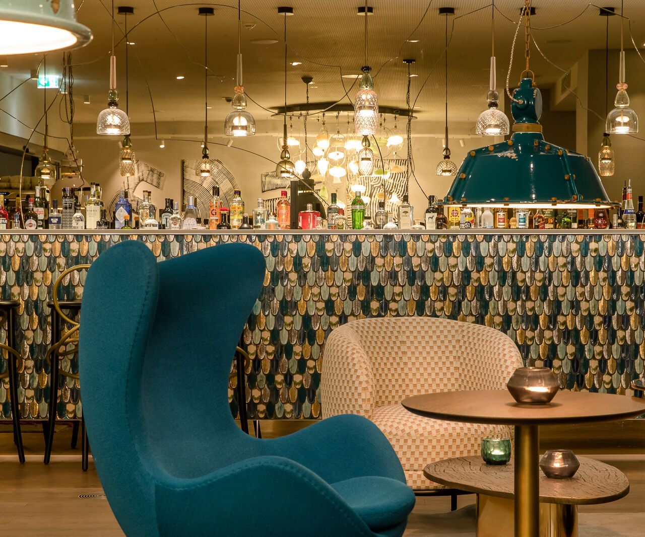 Hotel Linz Hauptplatz Motel One Lounge mit Sesseln, Egg chair und Bar im Hintergrund