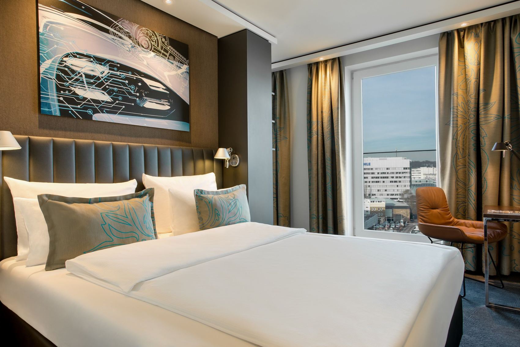 Designhotel Stuttgart Feuerbach Motel One Zimmer mit Doppelbett, Sessel und Tisch