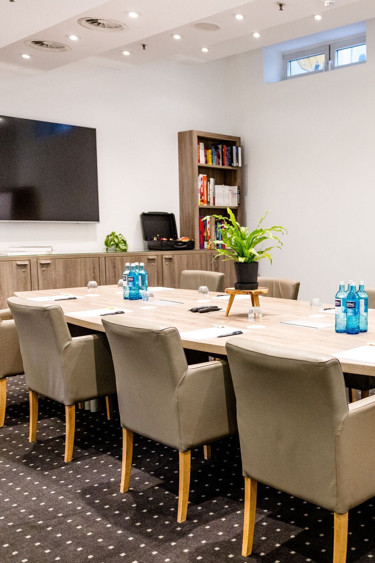 Hotel Frankfurt-Hauptbahnhof Motel One Conference room with large wooden table, upholstered armchairs, flipchart and television, ideal for meetings and presentations in a bright atmosphere. Hotel Frankfurt-Hauptbahnhof Motel One Conference room with large wooden table, upholstered armchairs, flipchart and television, ideal for meetings and presentations in a bright atmosphere.