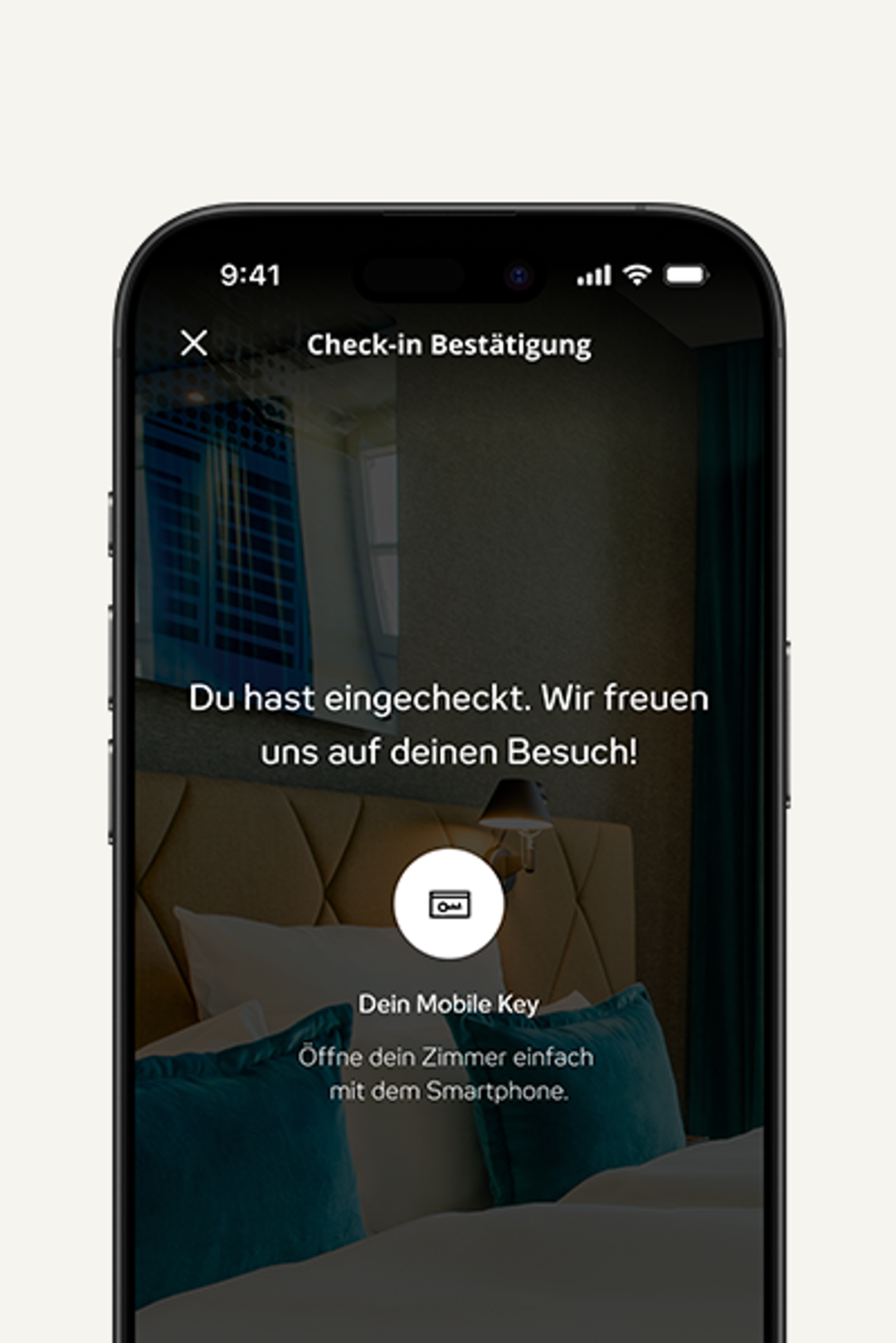 Smartphone-Bildschirm zeigt Check-in-Bestätigung: „Du hast eingecheckt. Wir freuen uns auf deinen Besuch!“ Hinweis, das Zimmer mit dem Smartphone per Mobile Key zu öffnen. Im Hintergrund stilvolles Hotelzimmer mit bequemem Bett und Kissen.