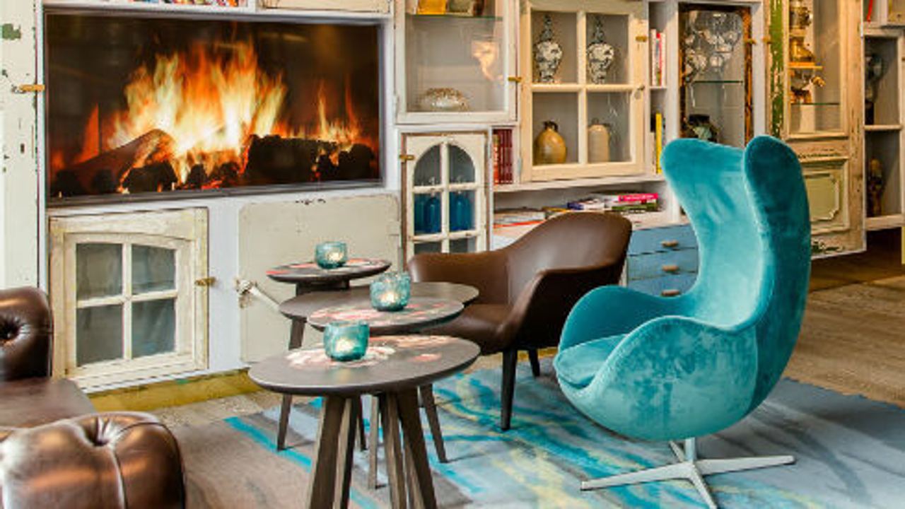 Hotel Amsterdam Waterlooplein Motel One Eggchair vor großem Regal mit TV