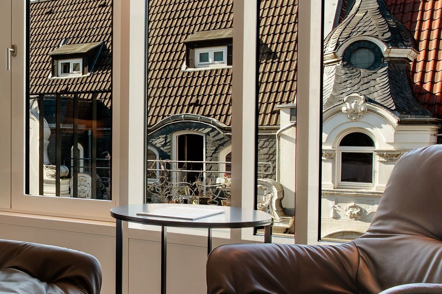 Hotel Aachen Motel One Zimmer Special One Doppelbett mit großer Fensterfront und Sessel