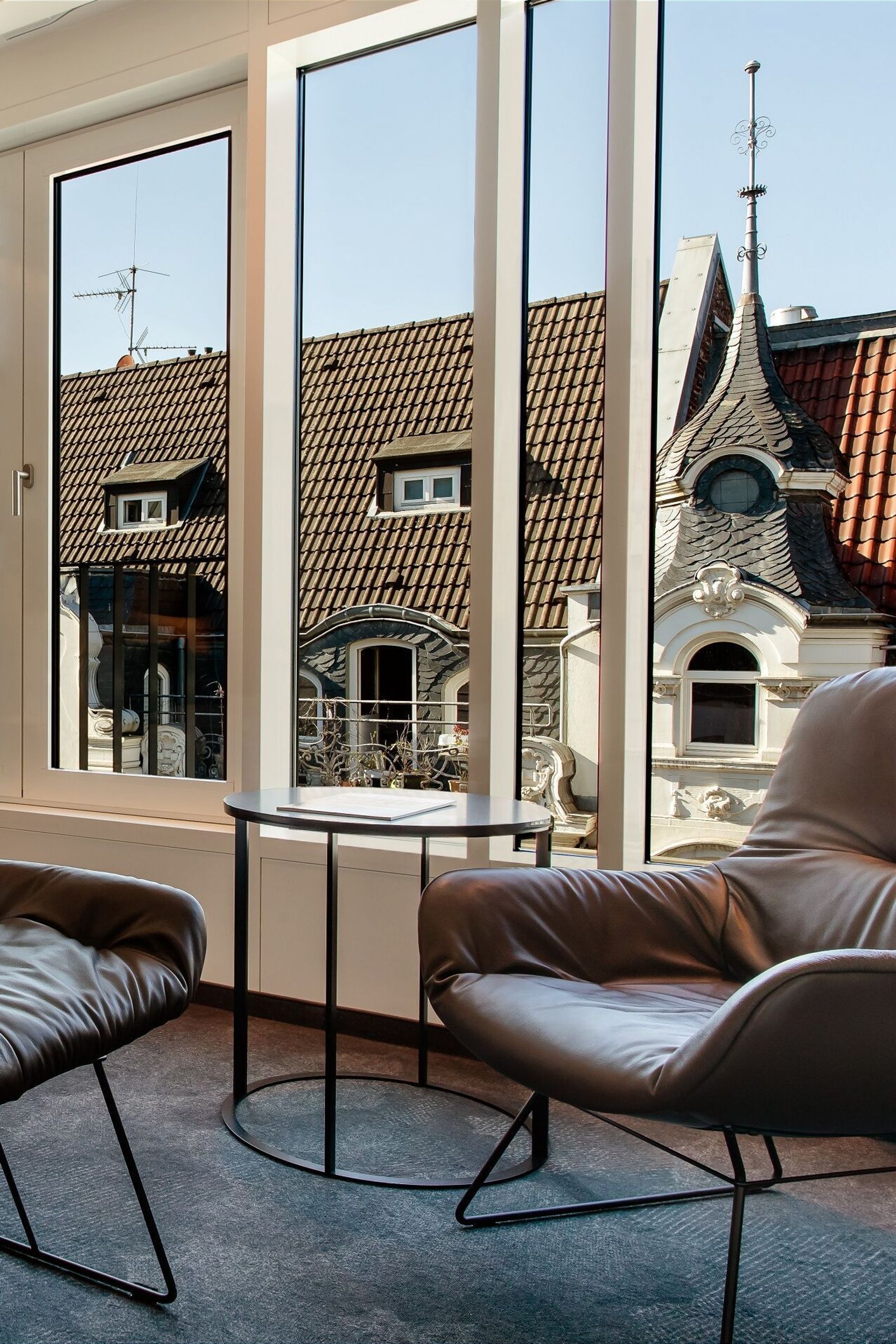 Hotel Aachen Motel One Zimmer Special One Doppelbett mit großer Fensterfront und Sessel