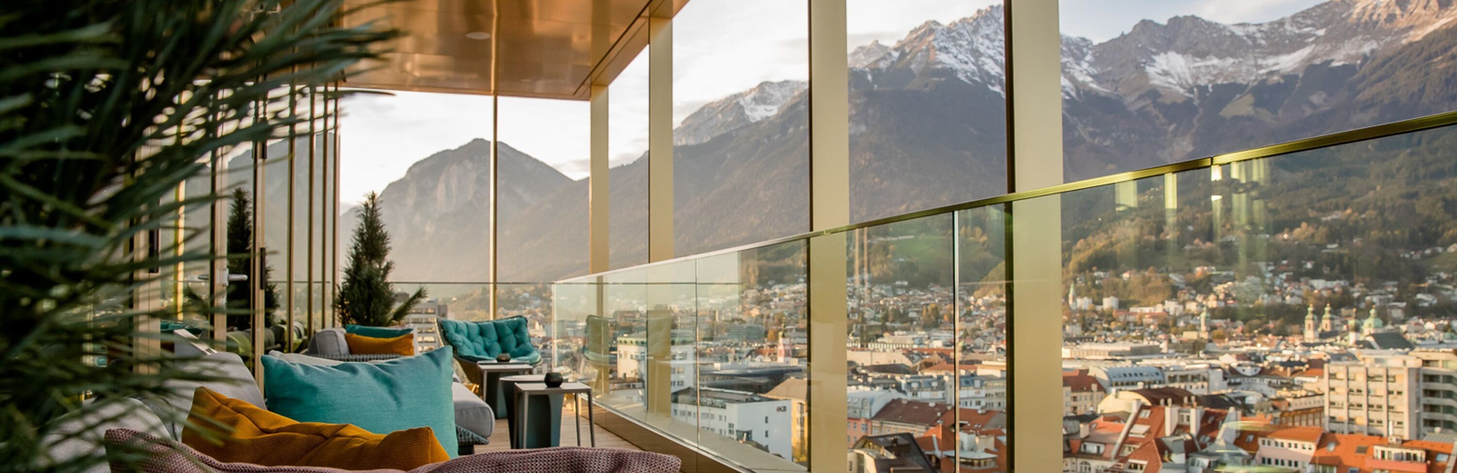 Hotel Innsbruck Motel One Zuschnitt Terrasse mit Sitzgelegenheiten sowie Panoramablick über die Stadt und die Berge