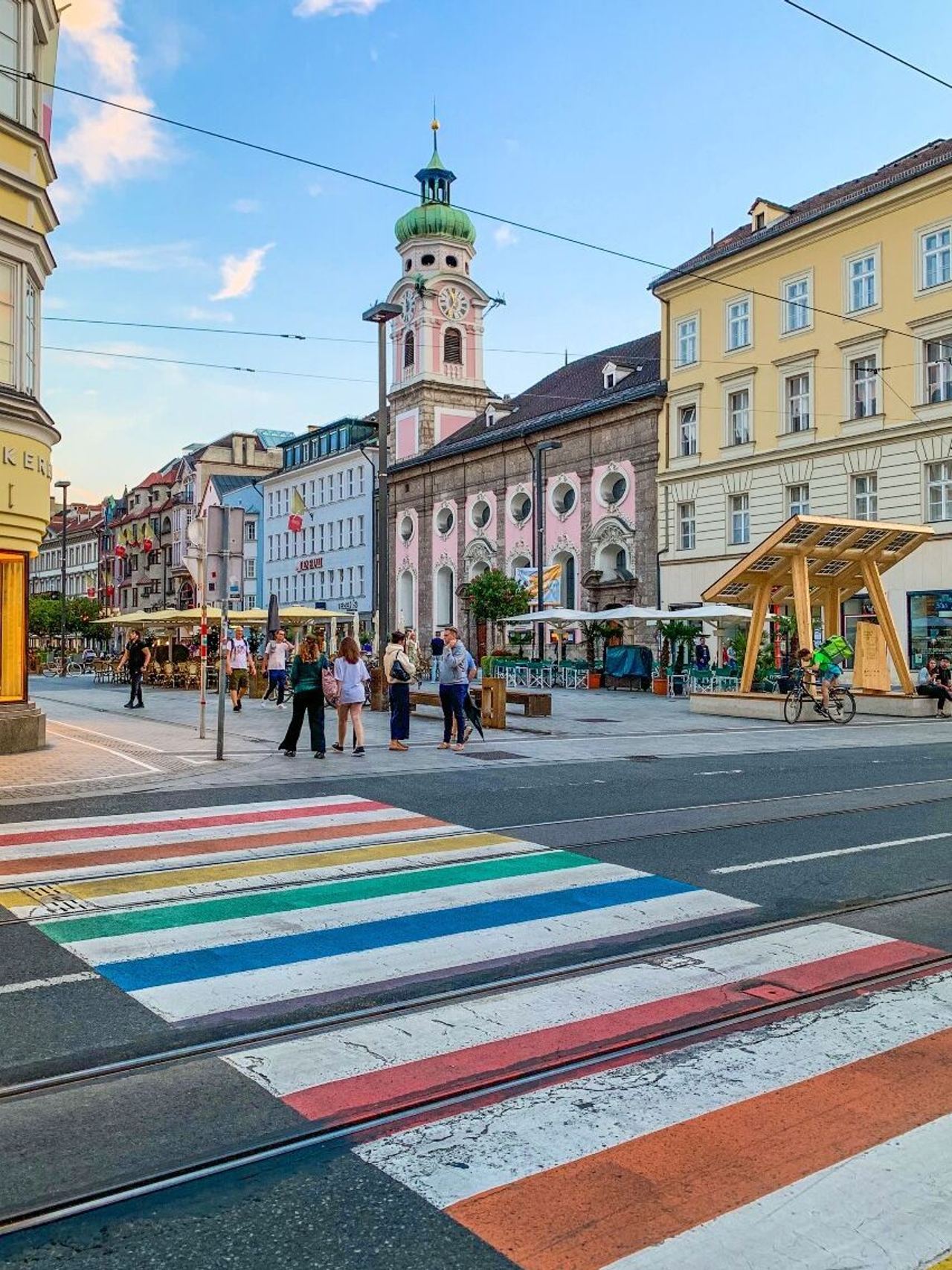 Hotel Innsbruck Innenstadt mit Zebrastreifen in Regenbogenfarben im Vordergrund Hotel Innsbruck Innenstadt mit Zebrastreifen in Regenbogenfarben im Vordergrund