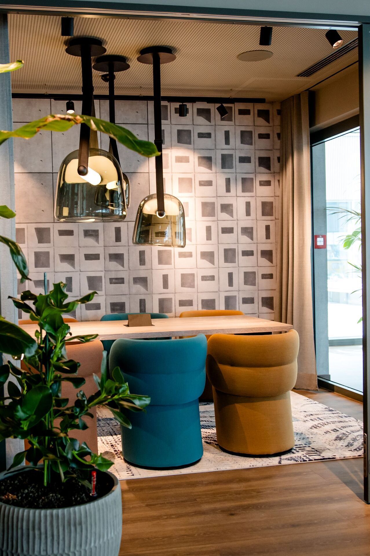 Hotel Vienna Donau City Motel One view through an open glass door into a meeting room with plants in the foreground