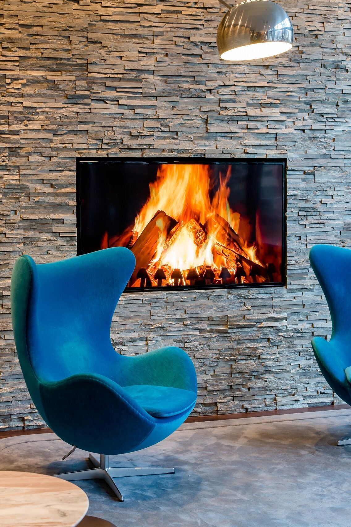 hotel Munich Sendlinger Tor Motel One two egg chairs in front of TV with fire