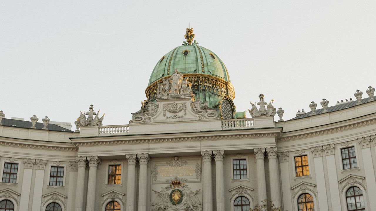 Historisches Gebäude mit einer großen grünen Kuppel, reich verzierten Fassaden und beleuchteten Fenstern, aufgenommen bei Tageslicht. Symbol für Kultur und Architektur in der Stadt. Historisches Gebäude mit einer großen grünen Kuppel, reich verzierten Fassaden und beleuchteten Fenstern, aufgenommen bei Tageslicht. Symbol für Kultur und Architektur in der Stadt.