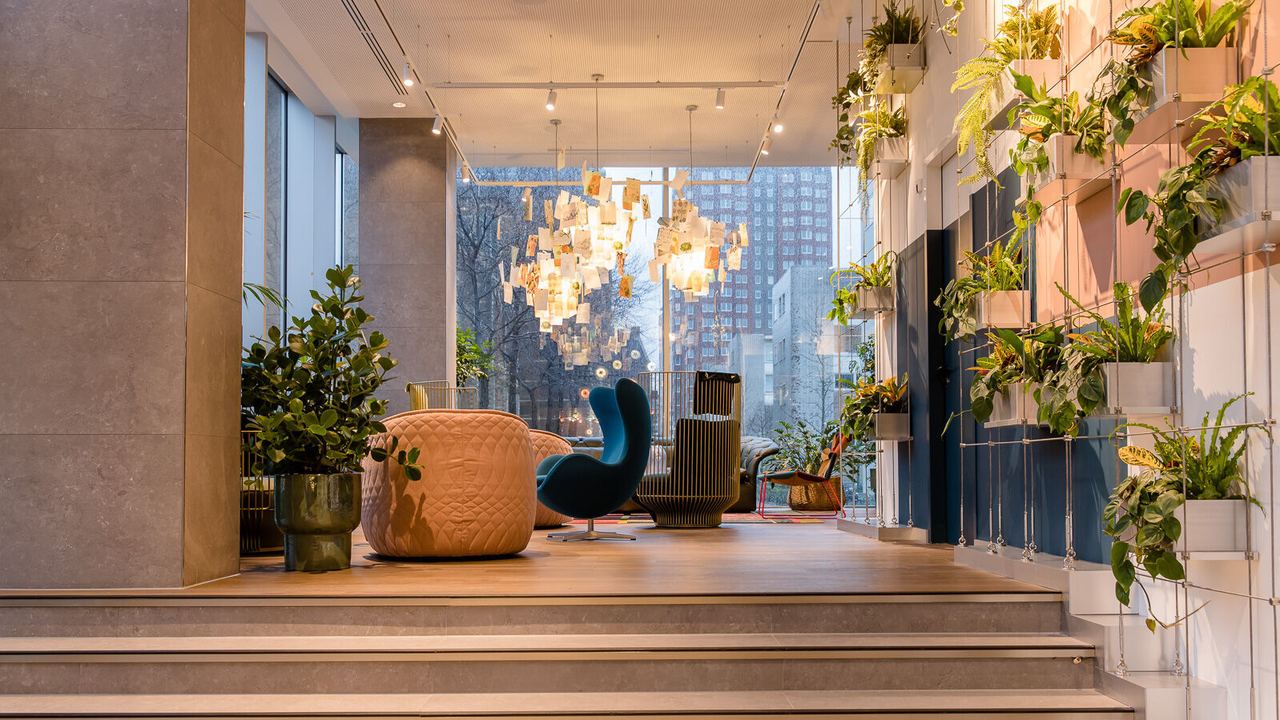 Designhotel Rotterdam Motel One lichtdurchfluteter Eingangsbereich mit Treppenstufen und Sitzgelegenheiten