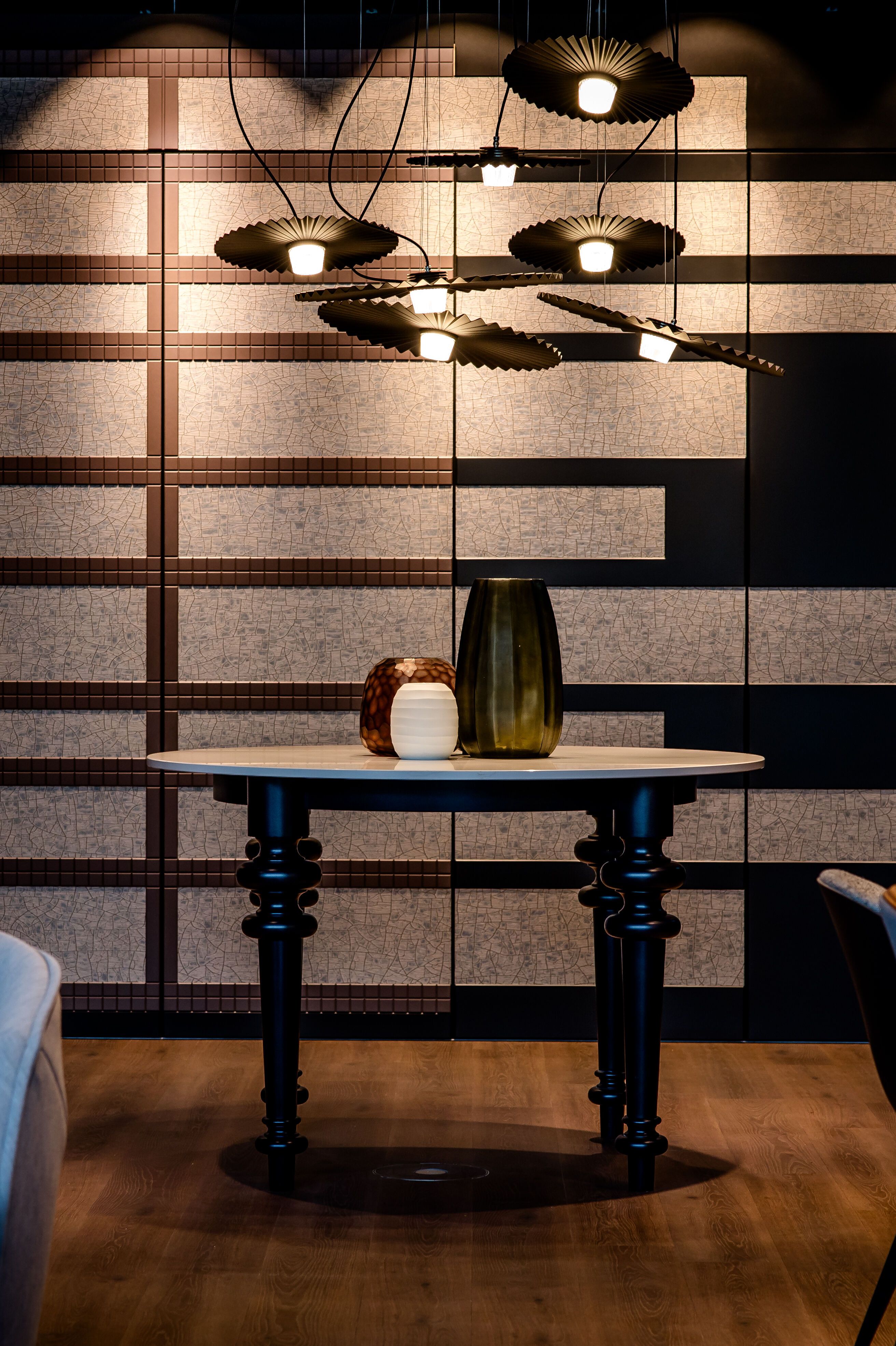 Hotel Karlsruhe Motel One Blick auf runden Tisch vor großer Wand sowie Stühle links und rechts vom Bild