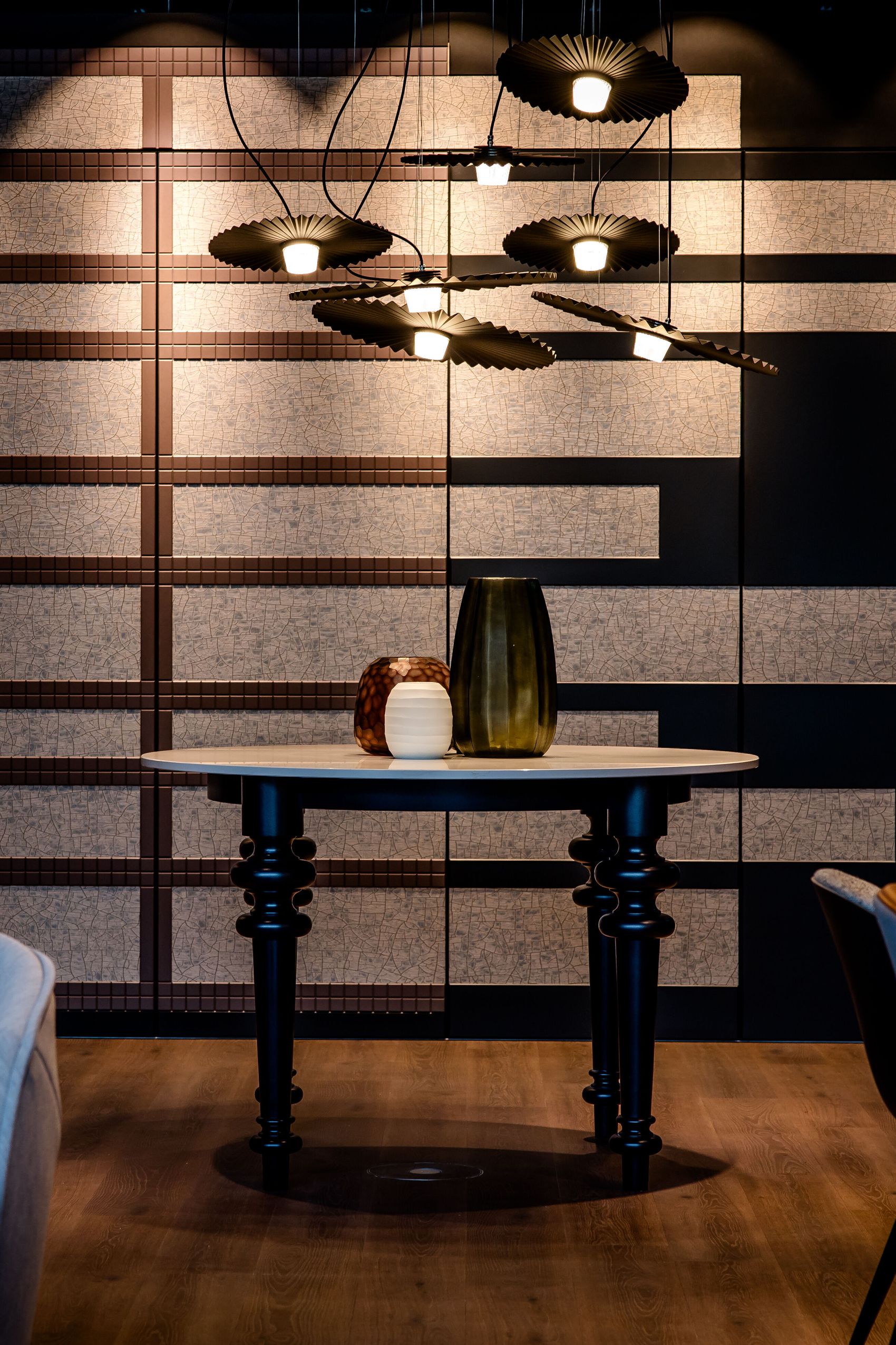 Hotel Karlsruhe Motel One Blick auf runden Tisch vor großer Wand sowie Stühle links und rechts vom Bild