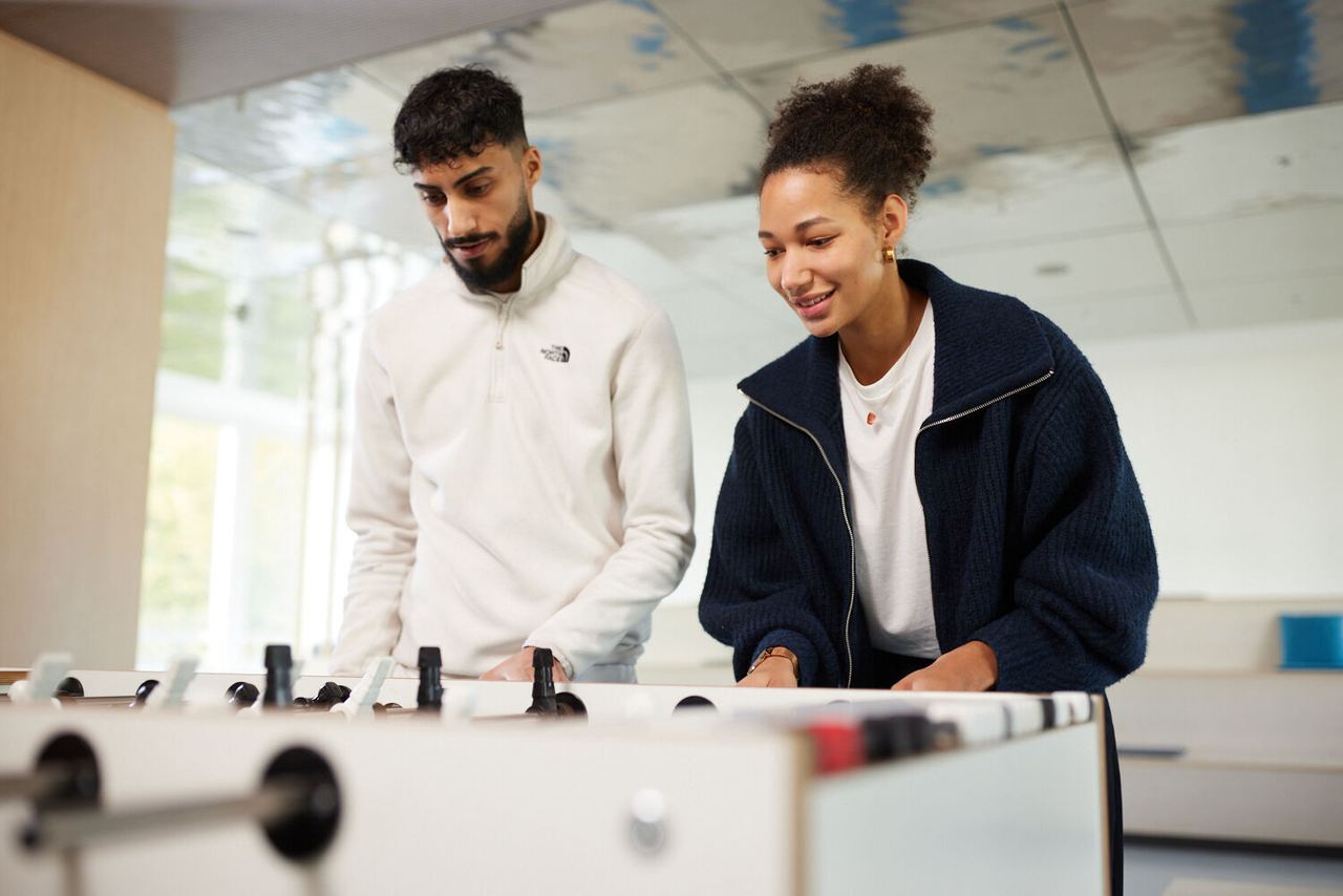 Ahmed playing table football with colleague