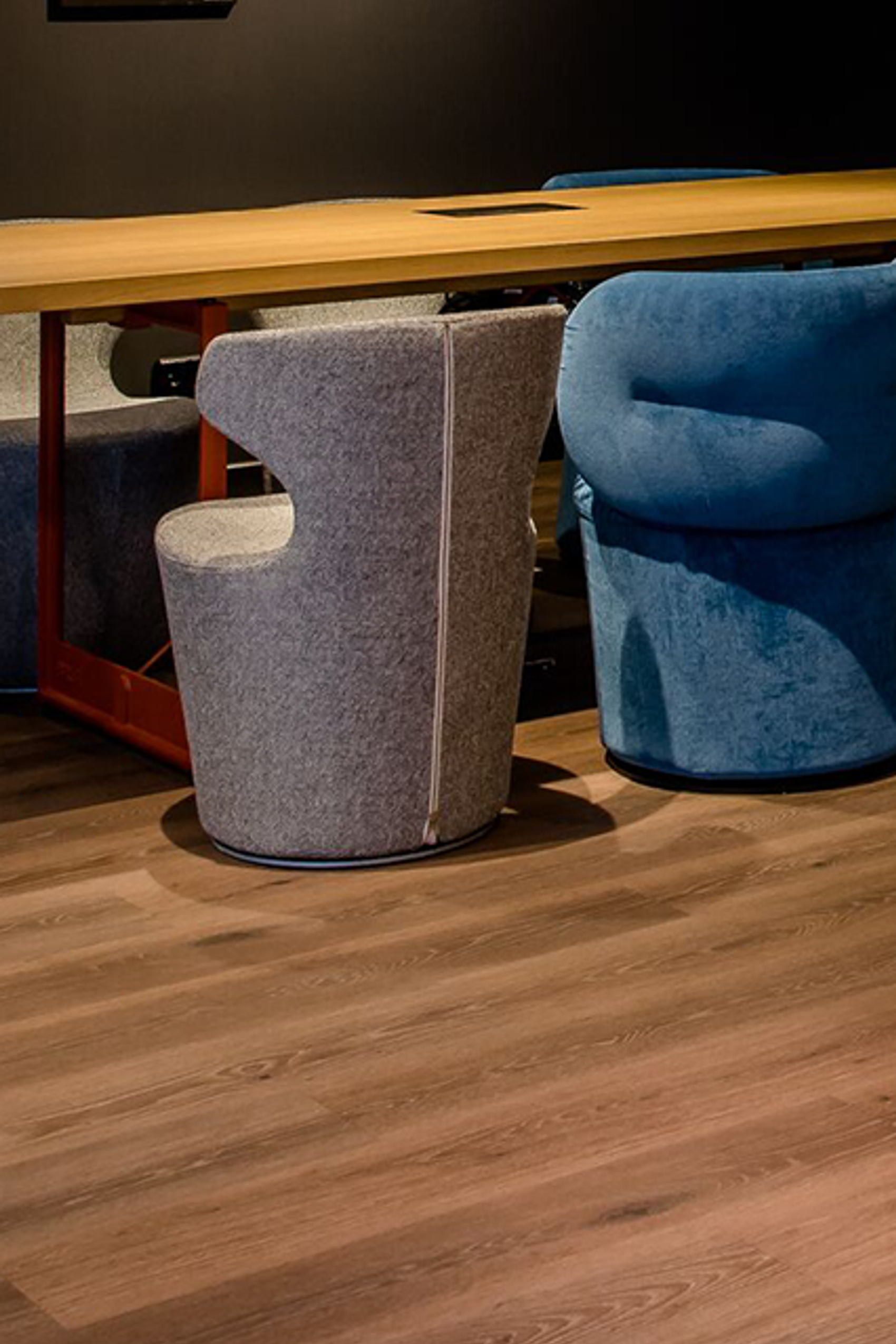 Sitzbereich mit großem Holztisch und bequemen, gepolsterten Sesseln in neutralen Farben
