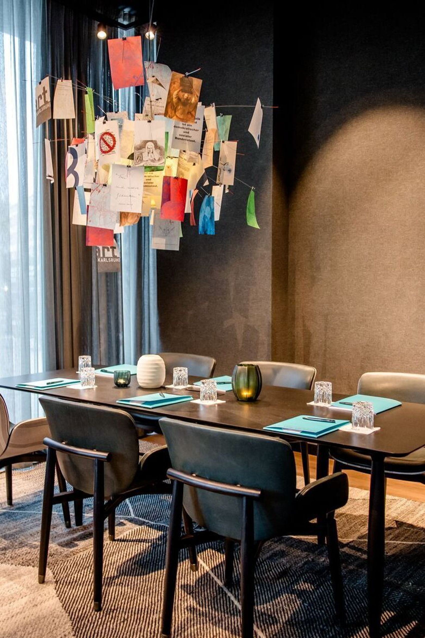 hotel Karlsruhe Motel One meeting room with table, six chairs and floor-to-ceiling window for plenty of light