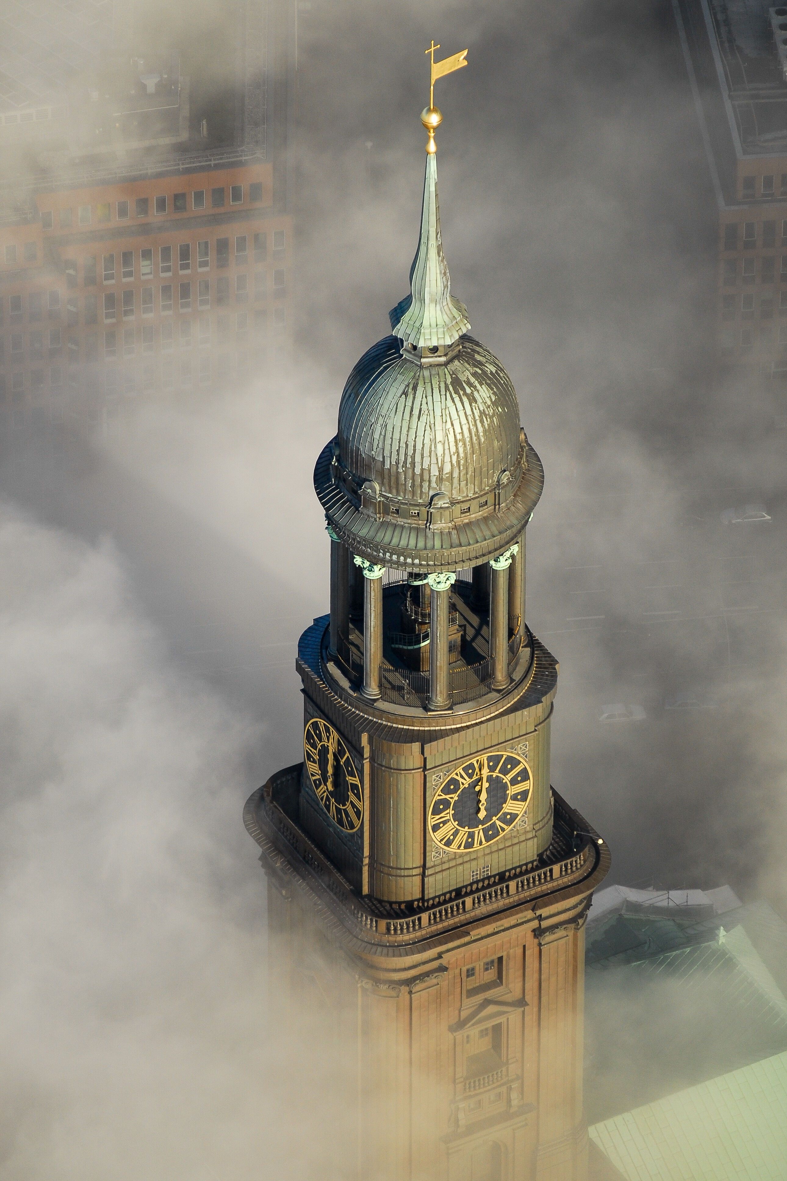 Turm mit kupferner Kuppel und vier großen Uhren, umgeben von Nebel. Symbolisches Wahrzeichen in einer urbanen Umgebung, vermittelt eine mystische und ruhige Atmosphäre.