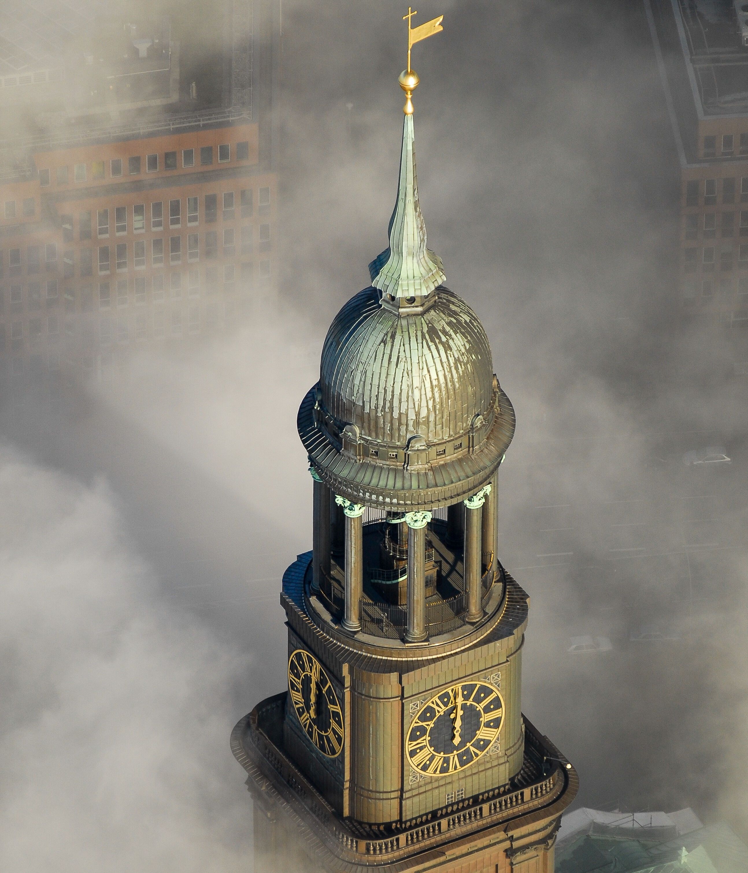 Turm mit kupferner Kuppel und vier großen Uhren, umgeben von Nebel. Symbolisches Wahrzeichen in einer urbanen Umgebung, vermittelt eine mystische und ruhige Atmosphäre.