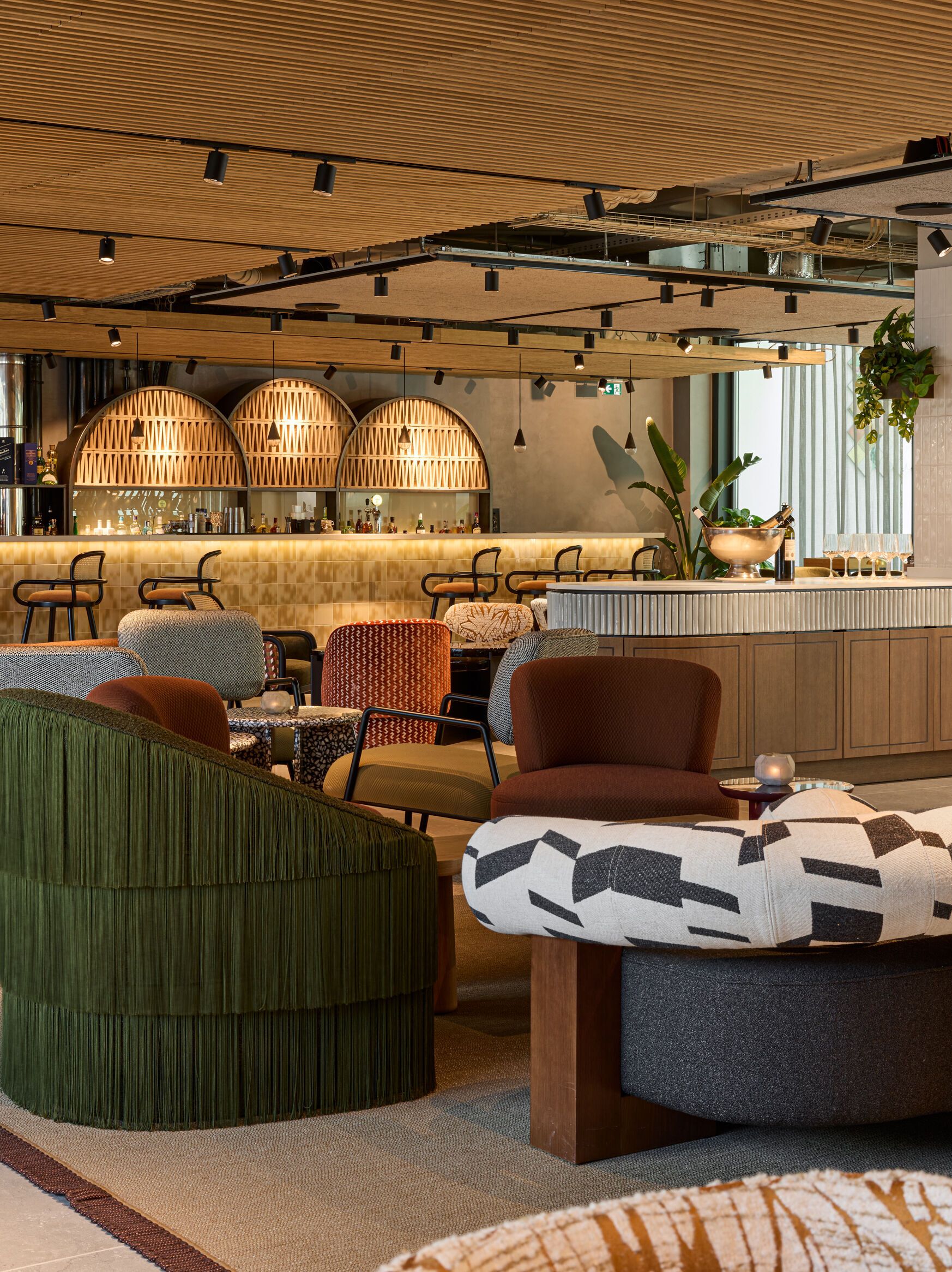 Hotel Lissabon The Cloud One Lounge und Barbereich mit Sitzgelegenheiten, warmem Holzdekor und atmosphärischer Beleuchtung.