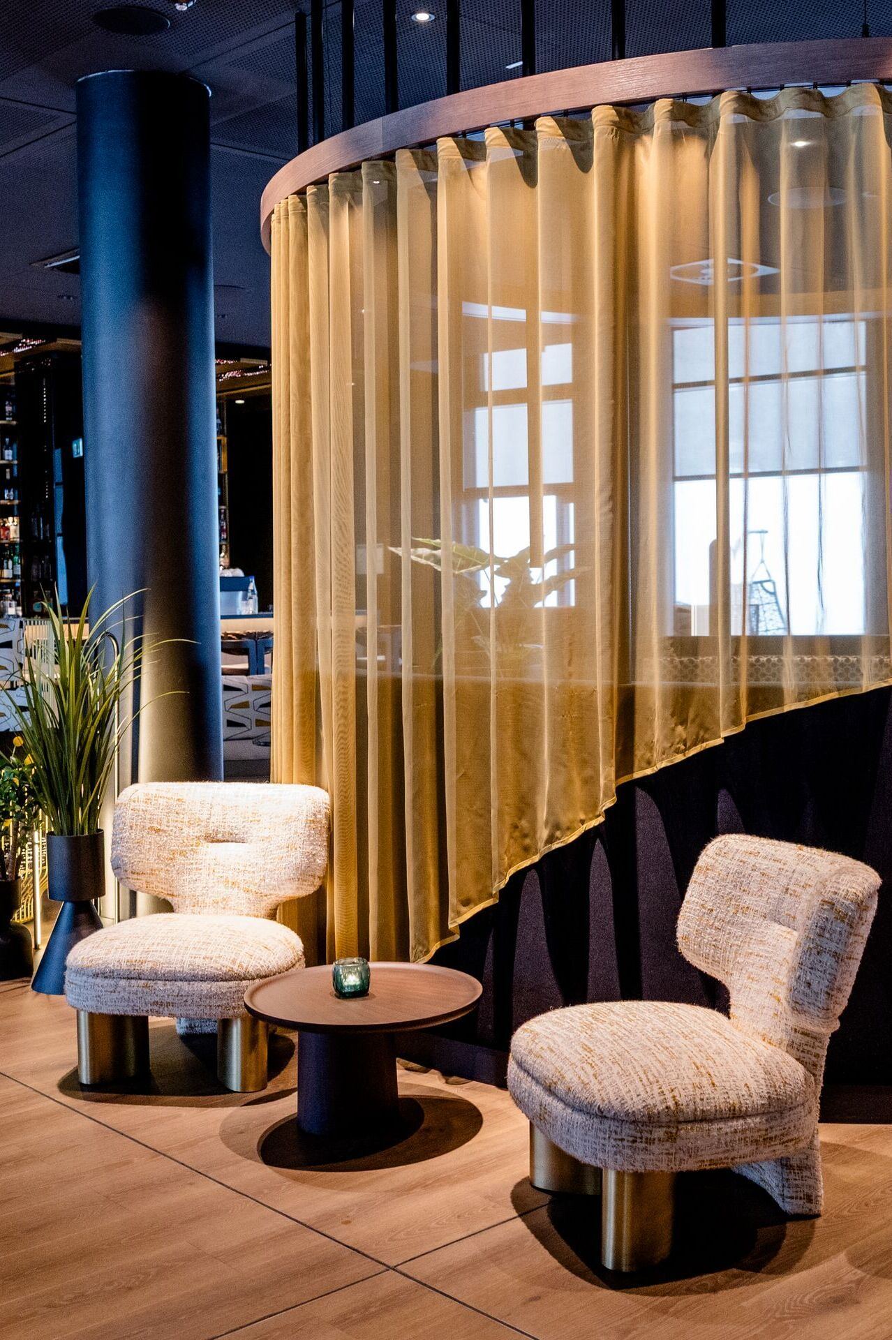 Hotel Frankfurt-Messe Motel One Lounge und Bar mit Sitzgruppe aus bequemen Sesseln, rundem Tisch und halbtransparentem Vorhang. Warme Beleuchtung und elegante Holz- und Stoffelemente. Hotel Frankfurt-Messe Motel One Lounge und Bar mit Sitzgruppe aus bequemen Sesseln, rundem Tisch und halbtransparentem Vorhang. Warme Beleuchtung und elegante Holz- und Stoffelemente.