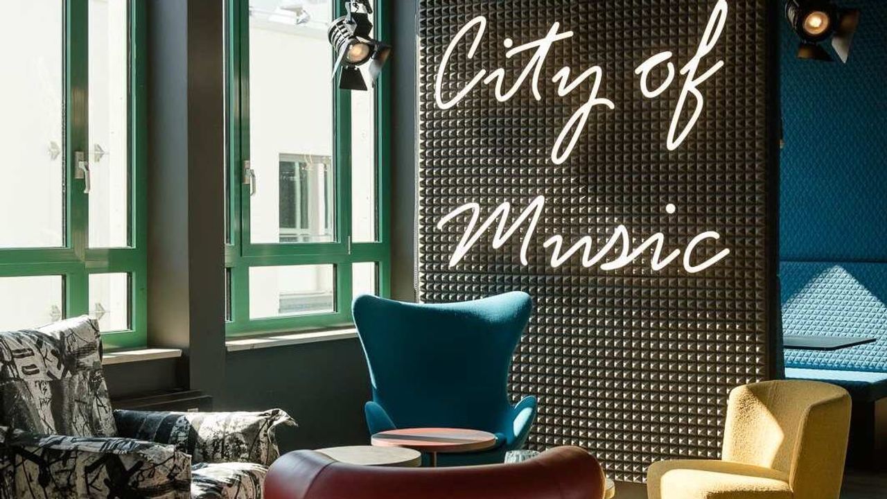 Hotel Mannheim Motel One Loungebereich mit Sesseln und "City of Music"-Wandaufschrift