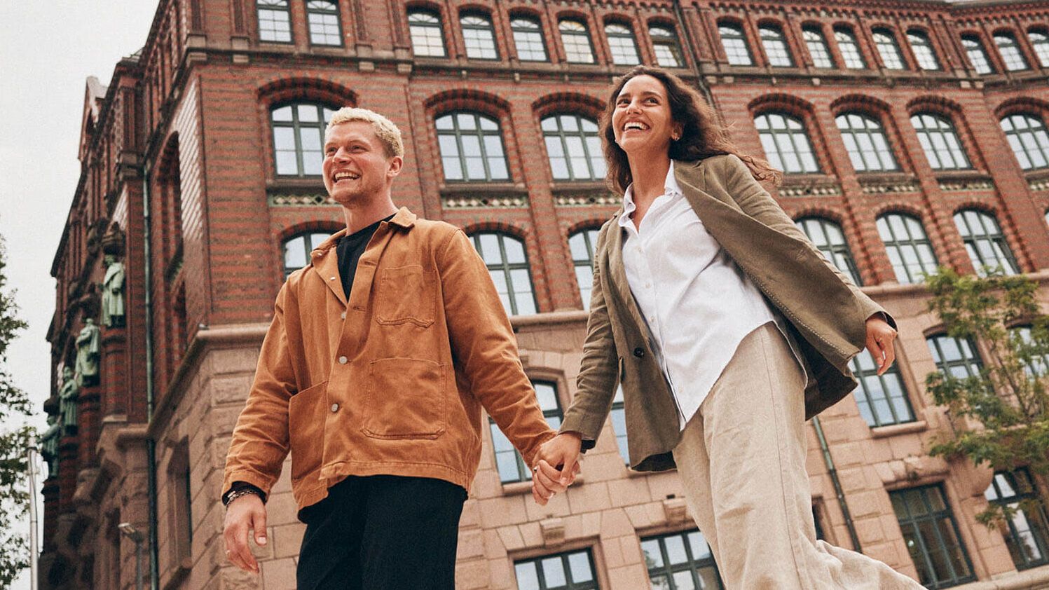 Hotel Hamburg Kontorhaus The Cloud One zwei Personen spazieren lächelnd und Hand in Hand
