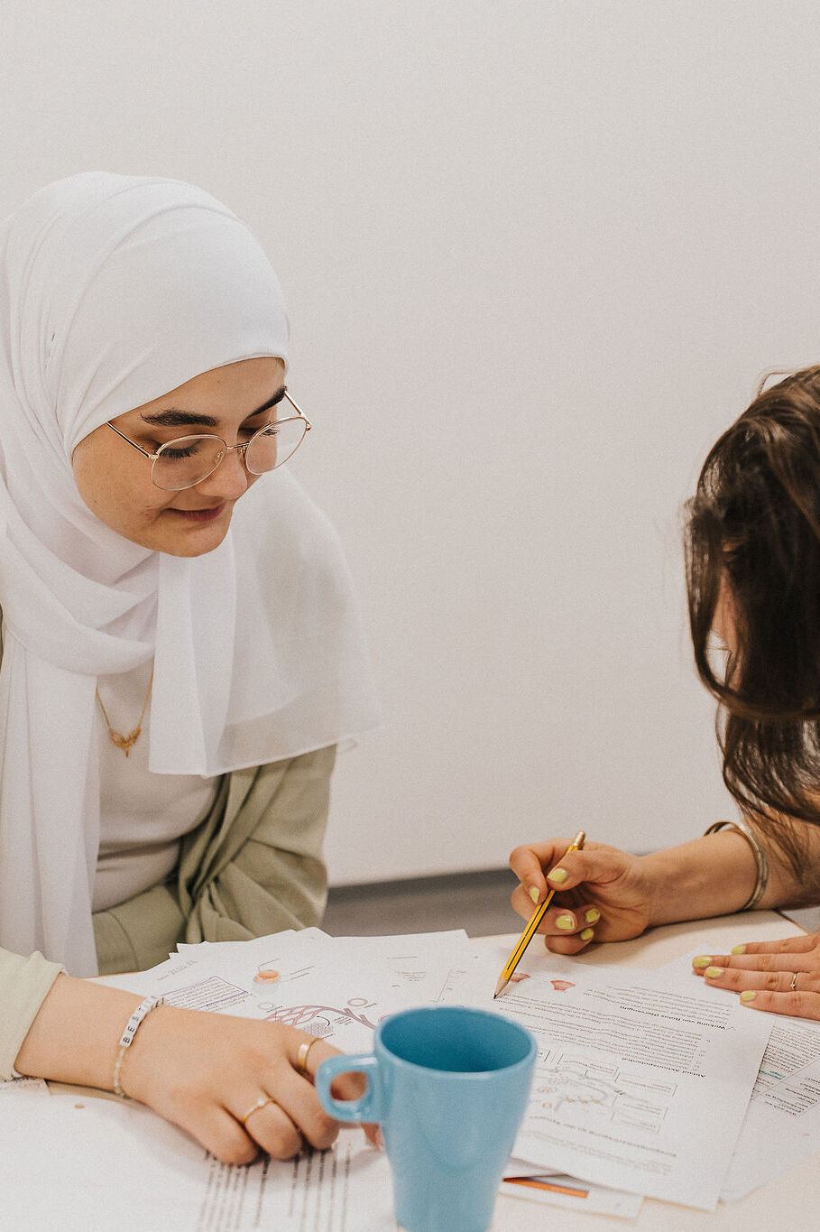 Zwei Frauen arbeiten gemeinsam an Dokumenten, konzentriert und kooperativ, in einer entspannten Lern- oder Arbeitssituation. Zwei Frauen arbeiten gemeinsam an Dokumenten, konzentriert und kooperativ, in einer entspannten Lern- oder Arbeitssituation.