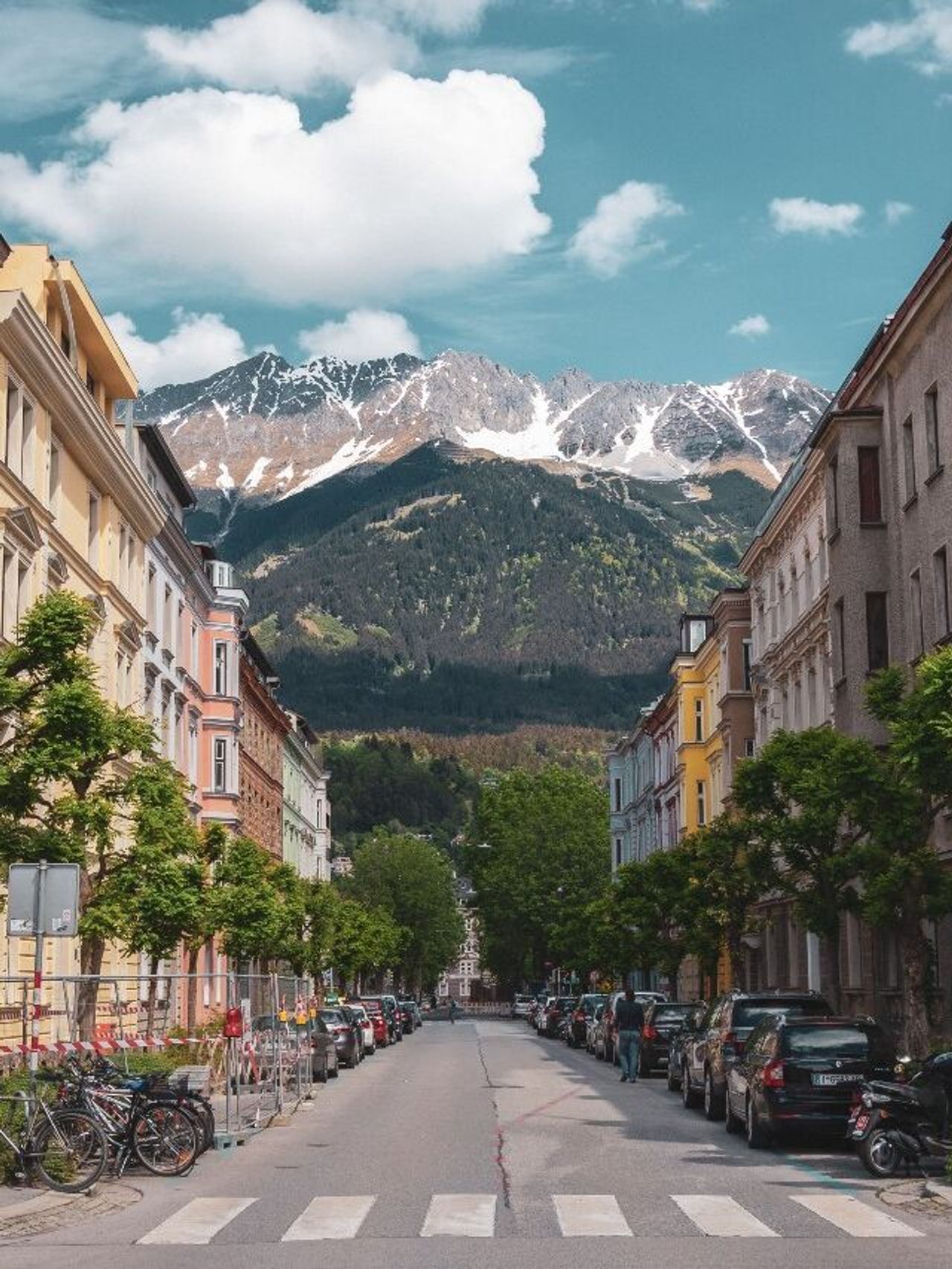 hotel Innsbruck Motel One wide street with houses to the left and right and a central view of the mountains hotel Innsbruck Motel One wide street with houses to the left and right and a central view of the mountains