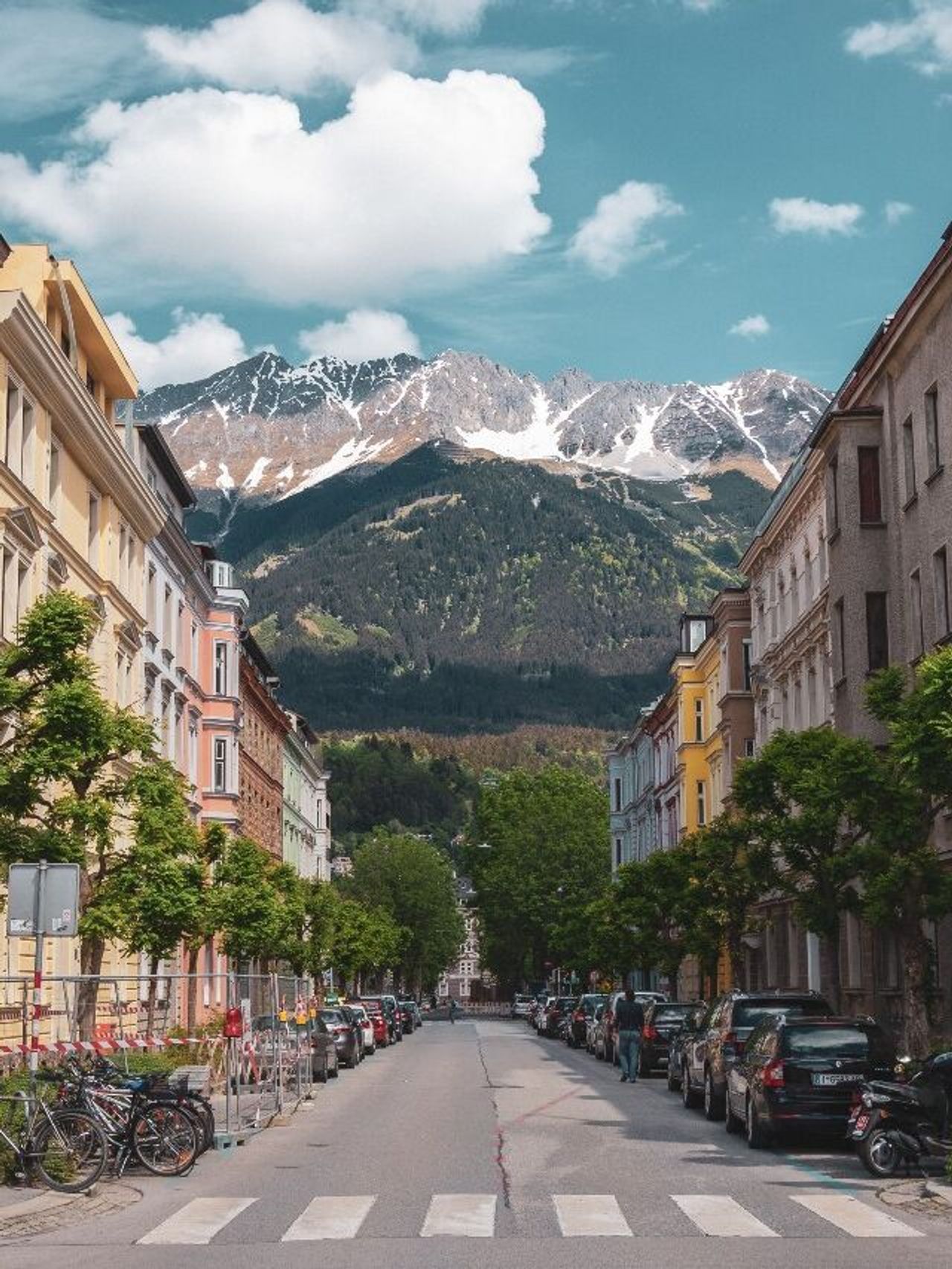 Hotel Innsbruck Motel One breite Straße mit Häusern links und rechts und mittiger Blick auf die Berge Hotel Innsbruck Motel One breite Straße mit Häusern links und rechts und mittiger Blick auf die Berge