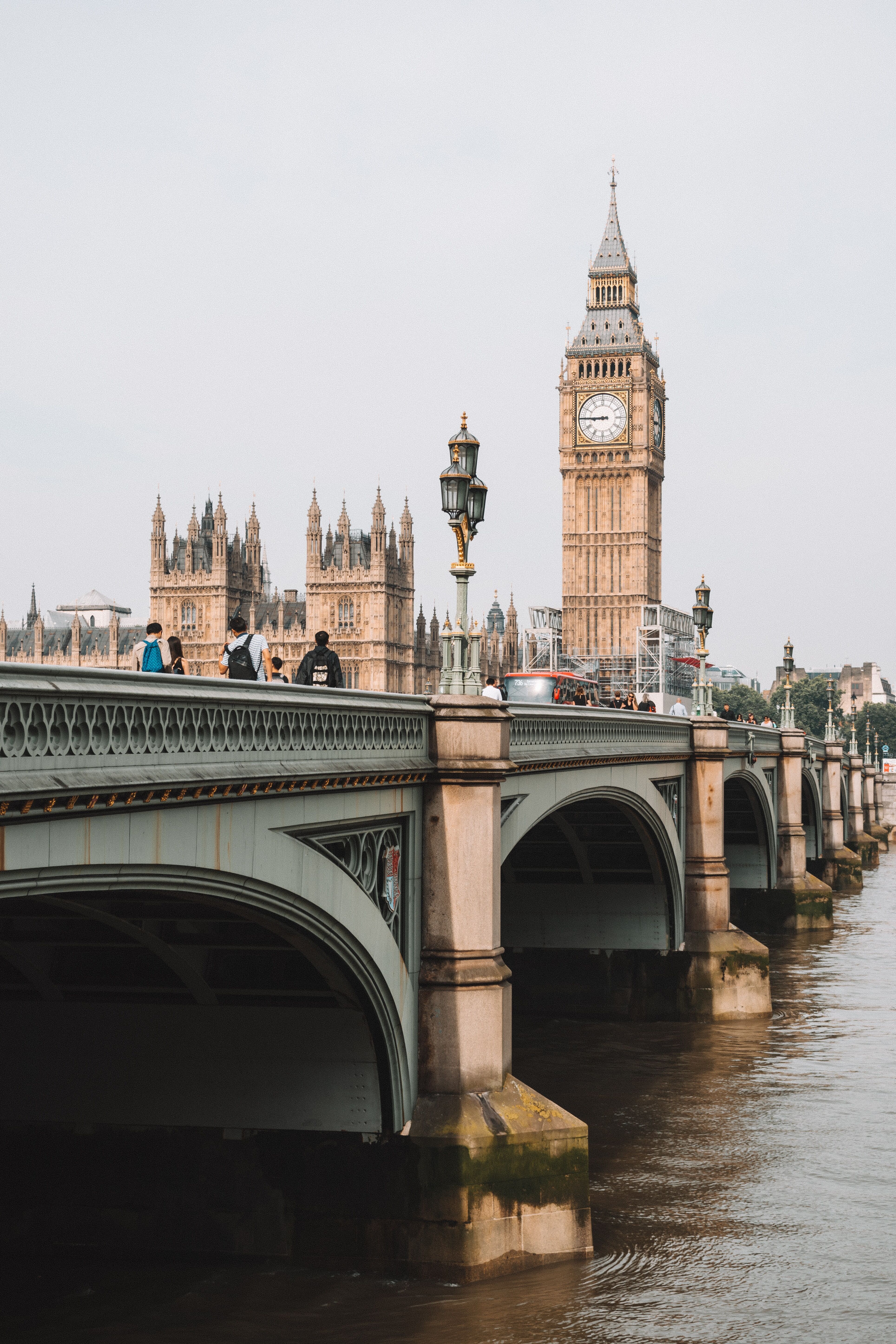 Blick auf die Westminster Bridge über die Themse mit Fußgängern, im Hintergrund ist der ikonische Uhrturm Big Ben und die Houses of Parliament in London zu sehen.