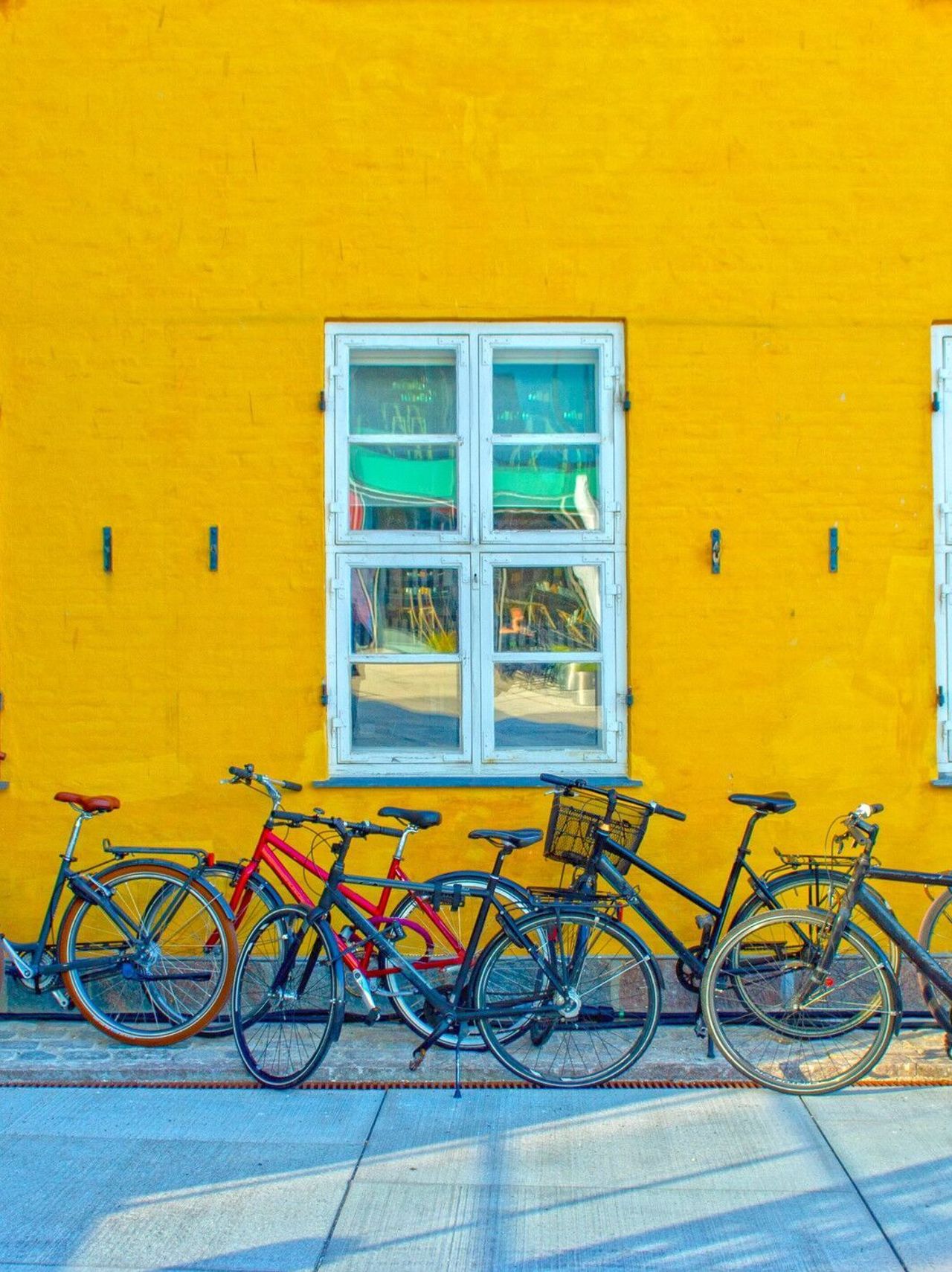 designhotel Copenhagen Motel One several bicycles in front of a yellow house wall designhotel Copenhagen Motel One several bicycles in front of a yellow house wall